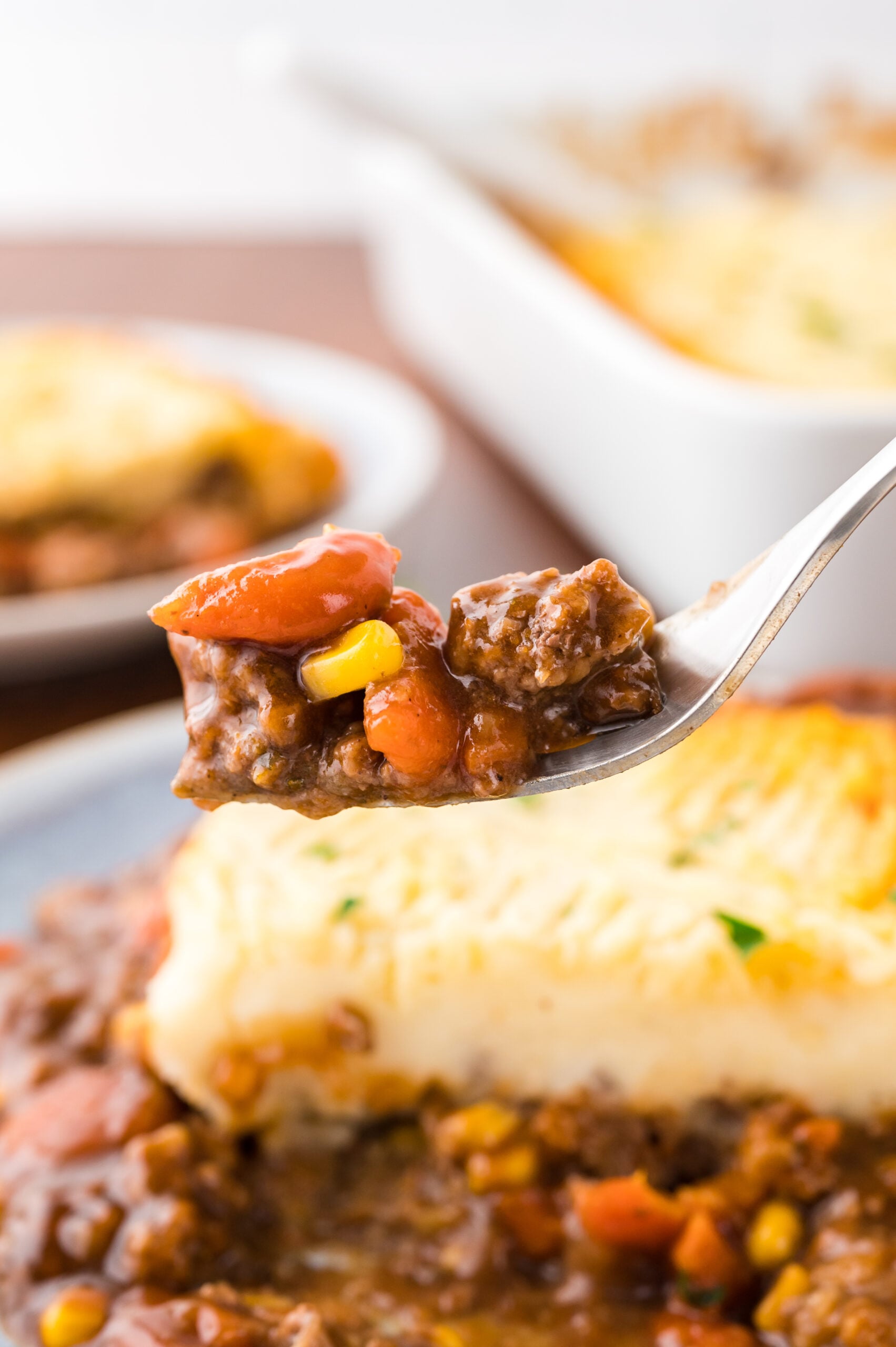 A fork removing a bite of Shepherd's pie.
