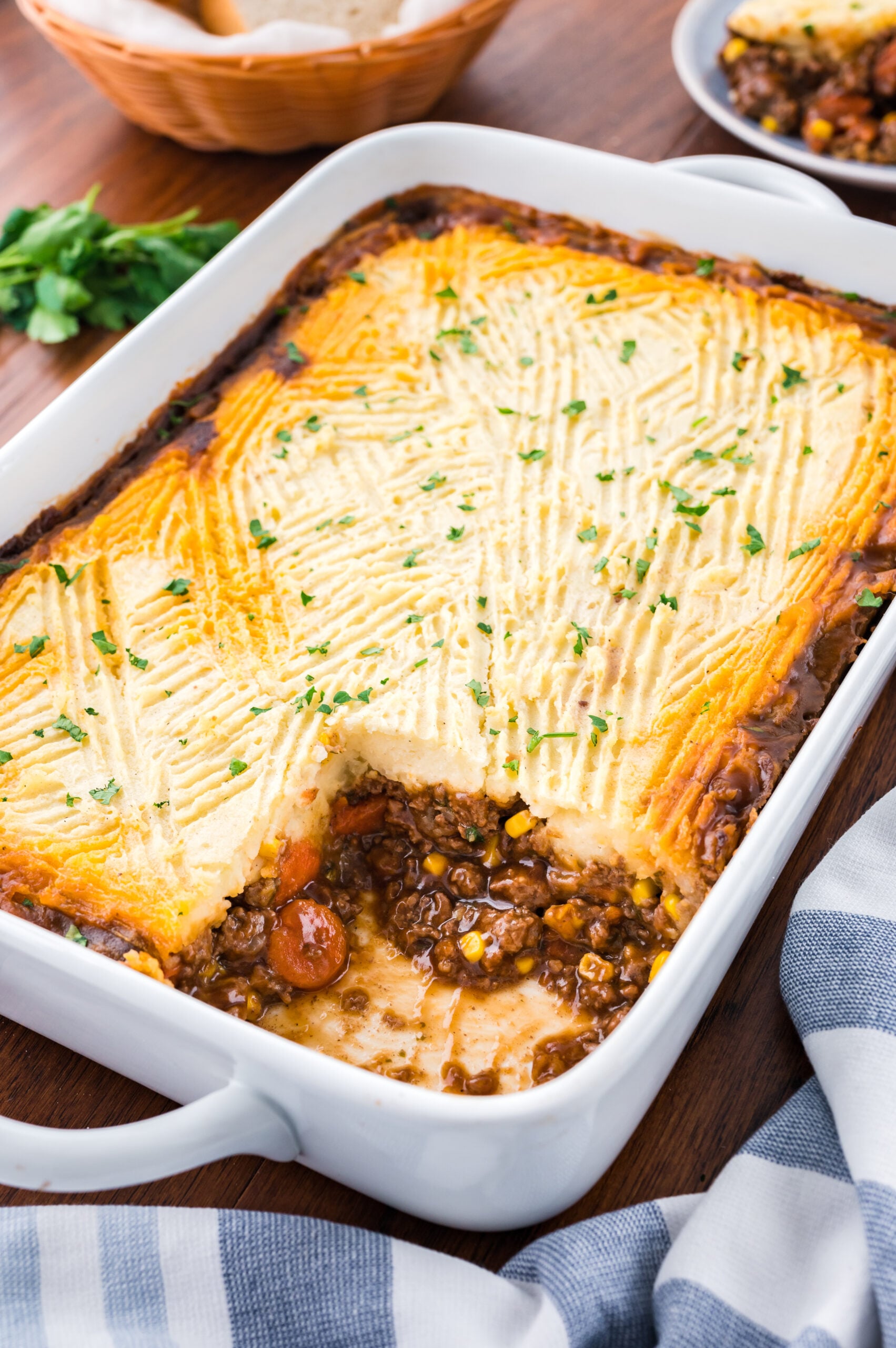Shepherds pie in a white casserole baking dish with a slice removed