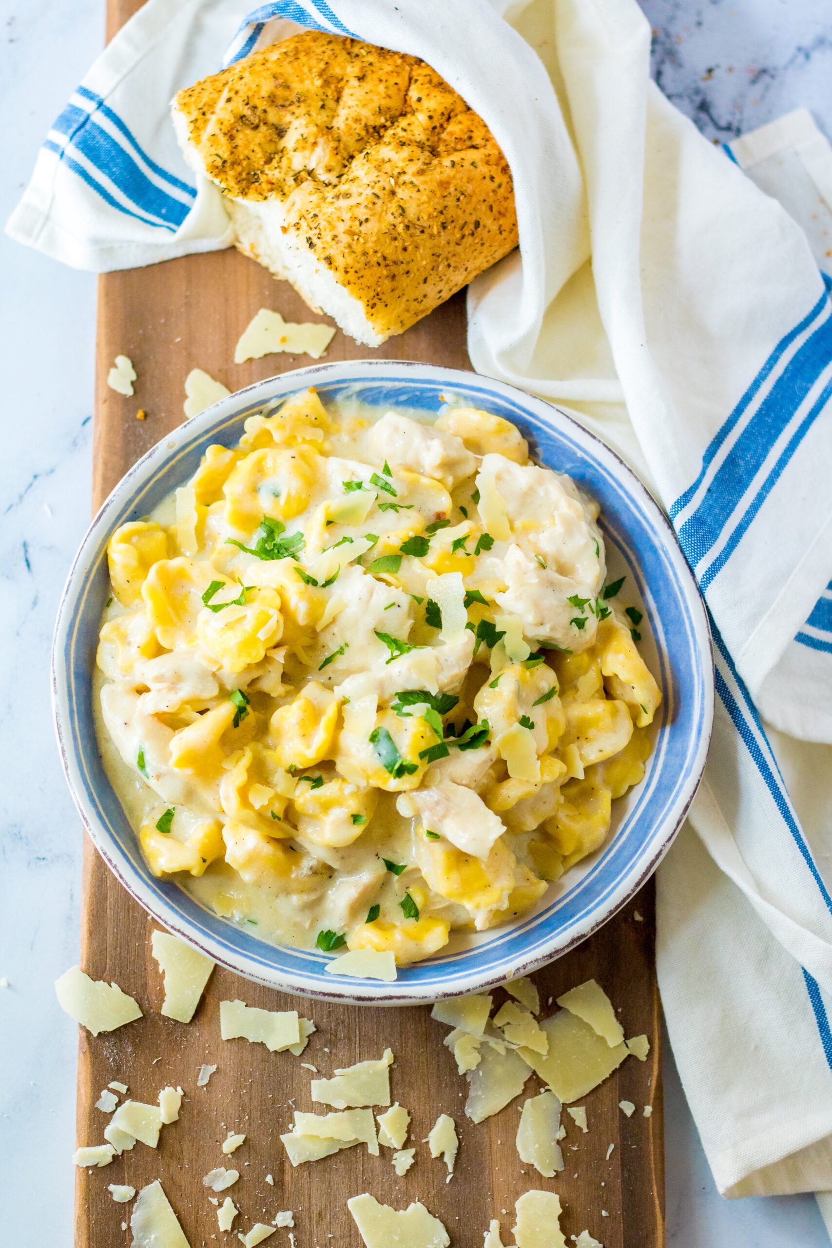 Overhead view of Slow Cooker Chicken Tortellini in a white and blue bowl.