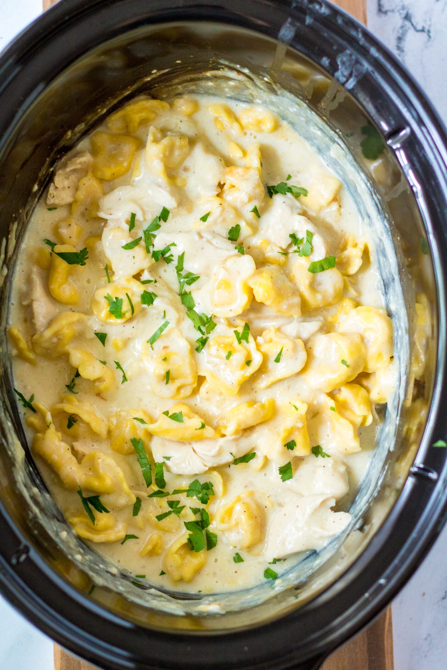 Overhead view of Slow Cooker Chicken Tortellini in a crock pot.
