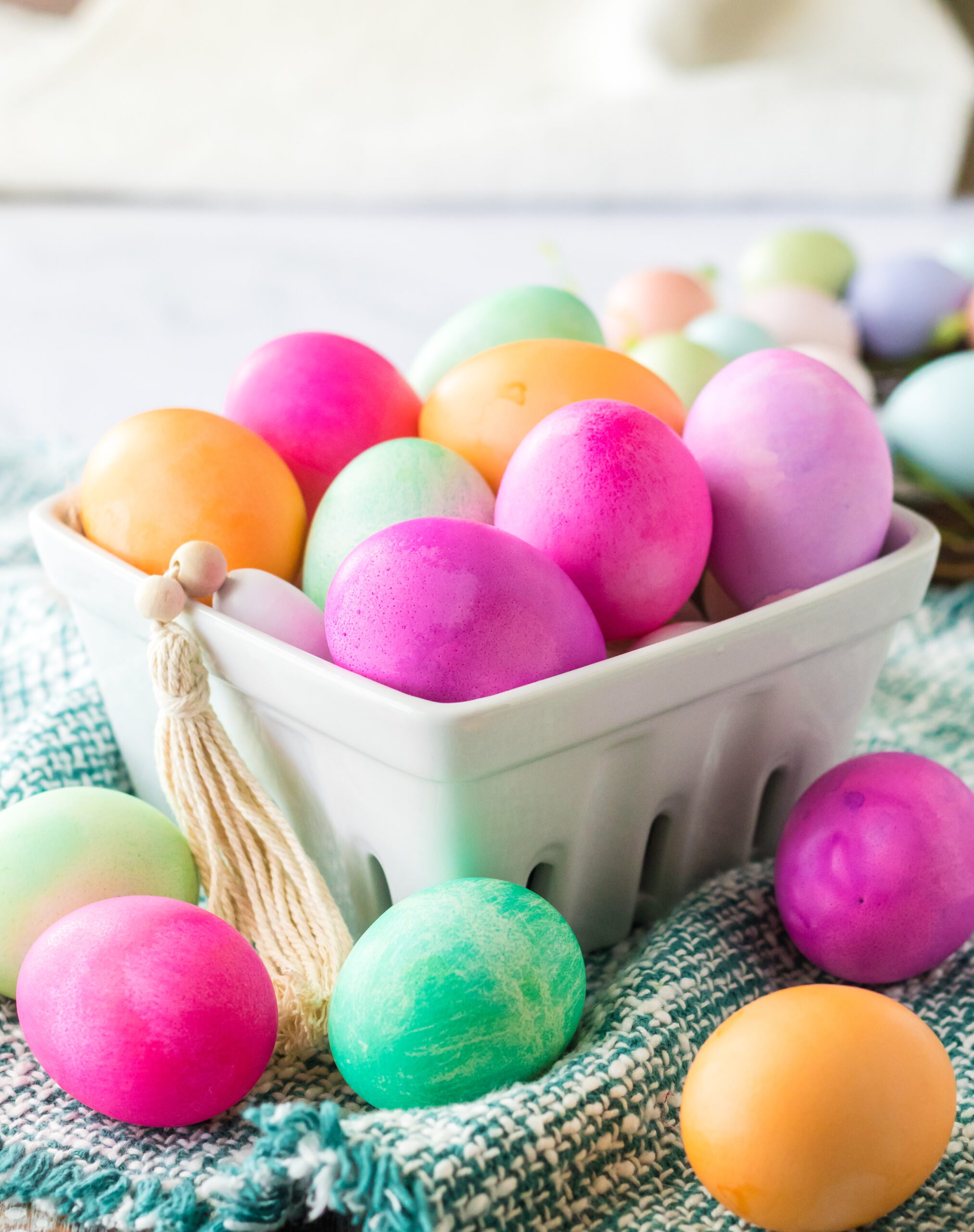 Dyed Easter Eggs in a white glass container.