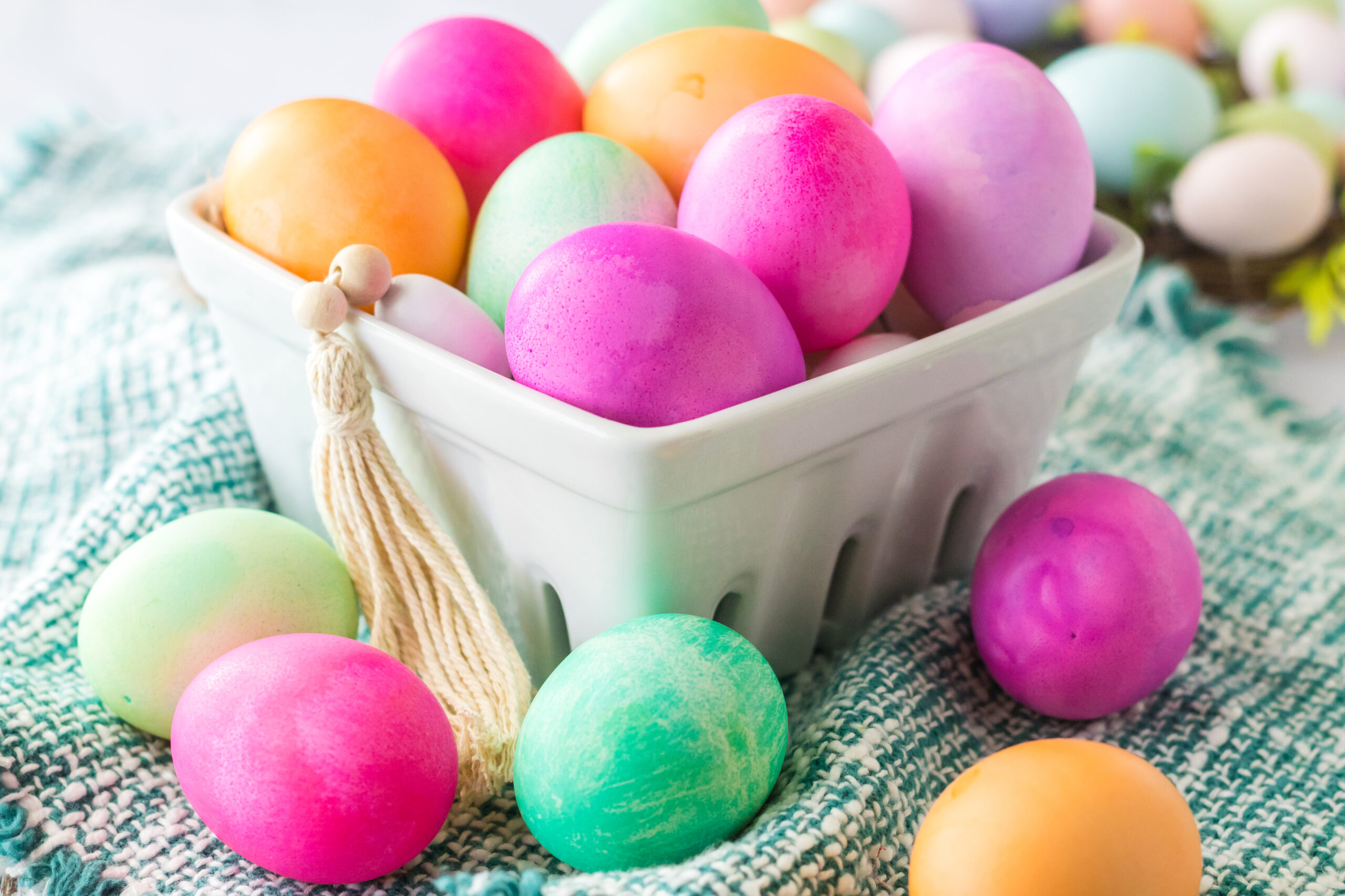 Dyed Easter Eggs in a white glass container.