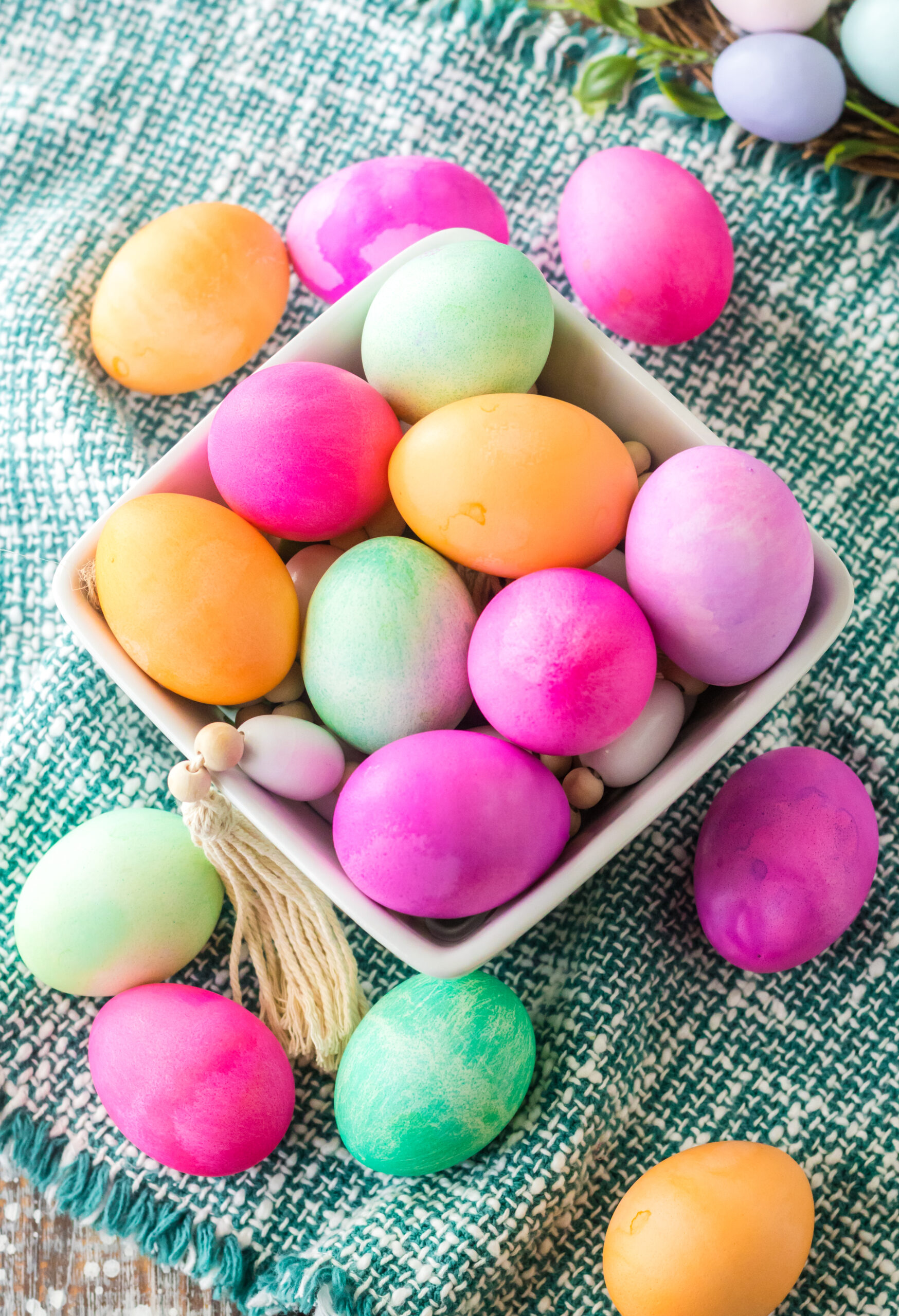 Overhead view of Dyed Easter Eggs in a white glass container.