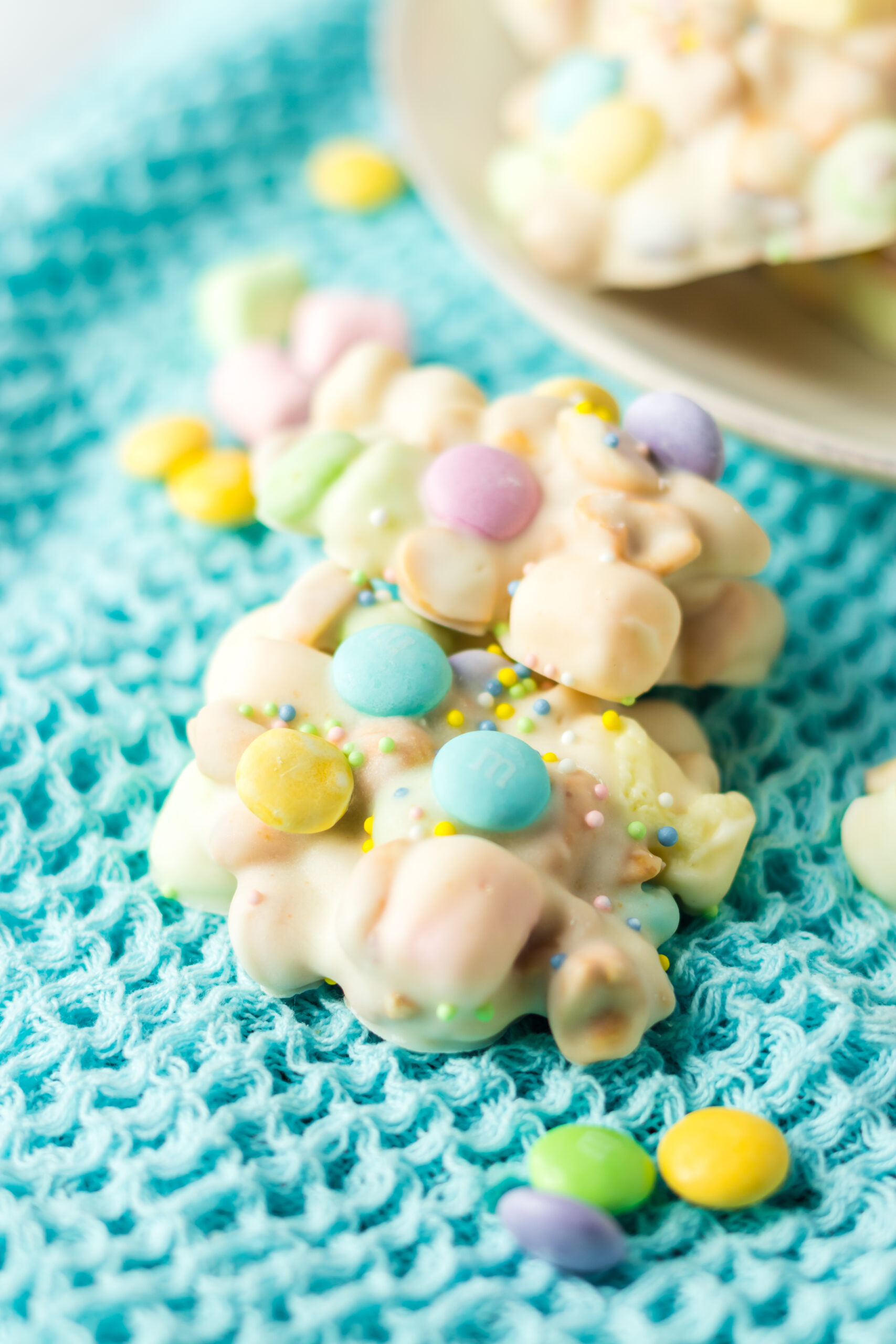 Two pieces of slow cooker Easter candy on a teal linen.