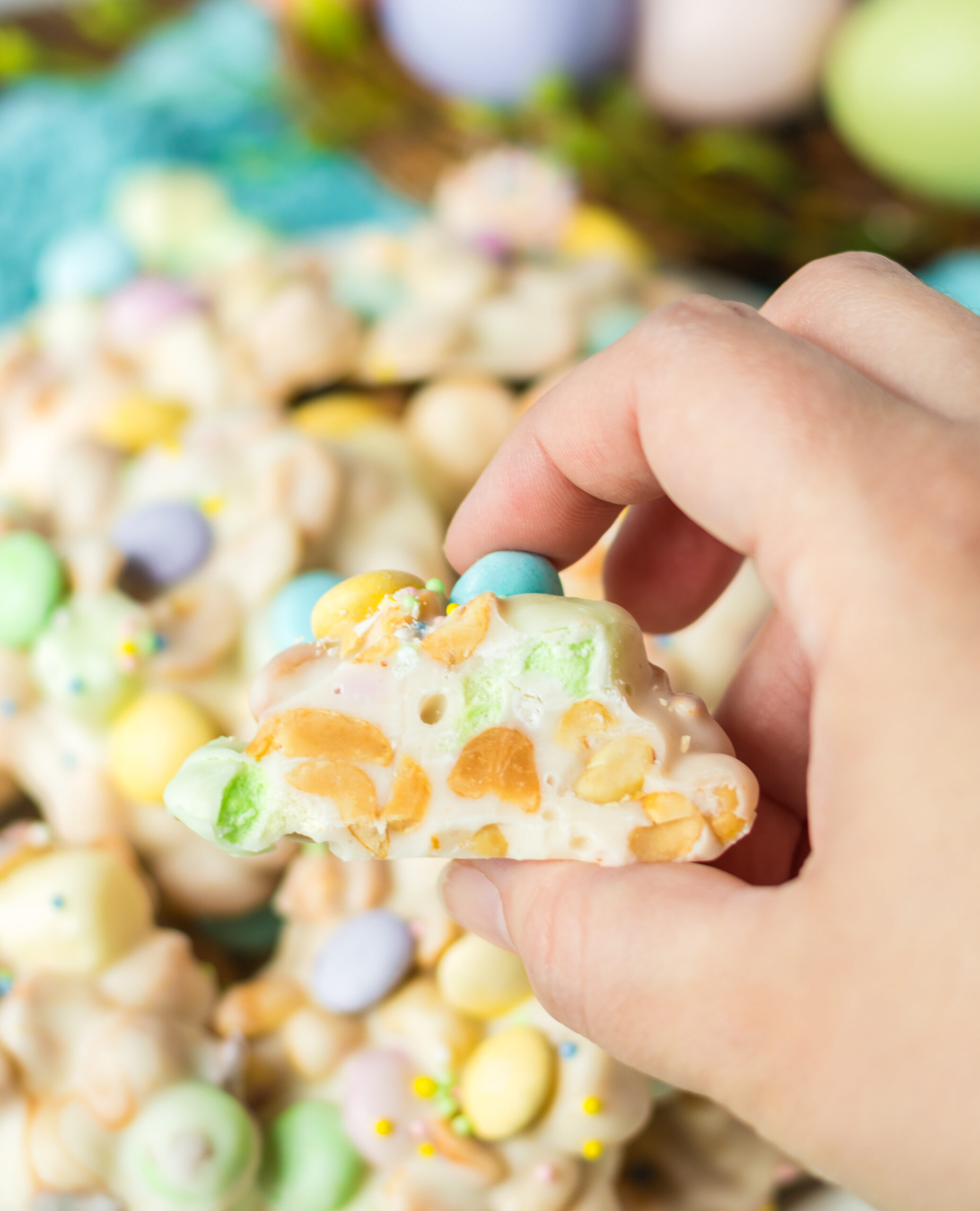 A hand holding a piece of Easter candy with a bite removed.