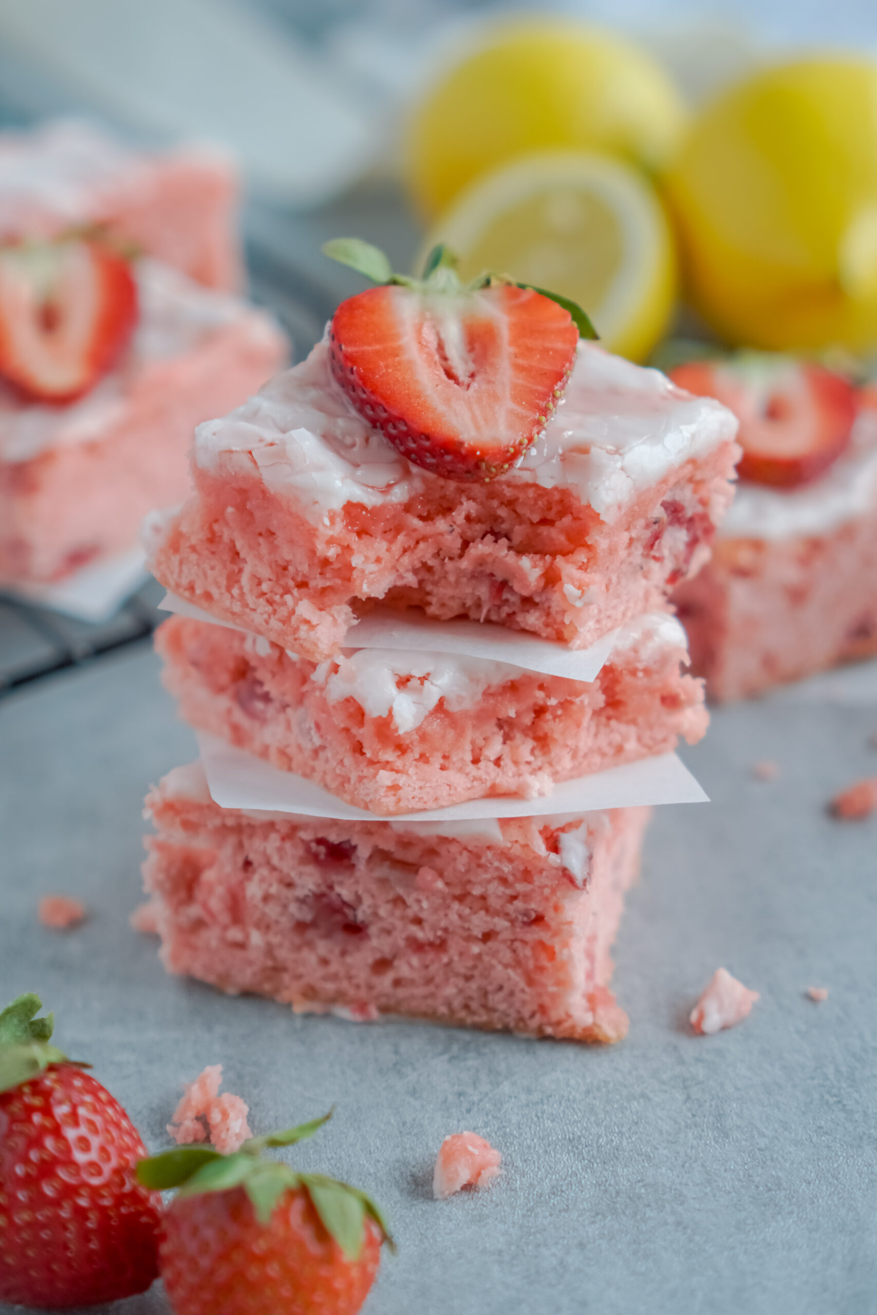 Front view of three Strawberry Lemon Brownies stacked with a bite removed from the top brownie.