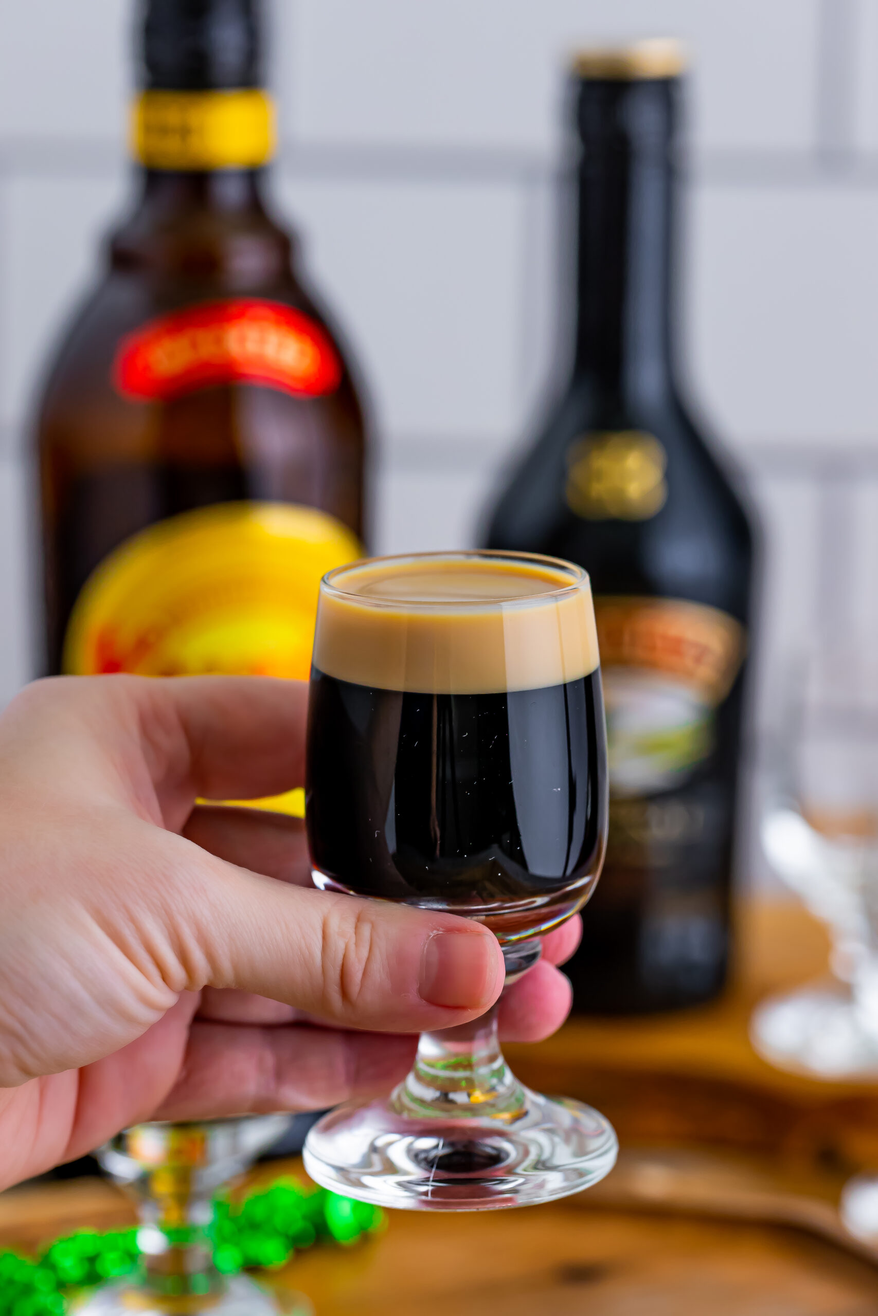 A hand holding a baby Guinness Shot. 
