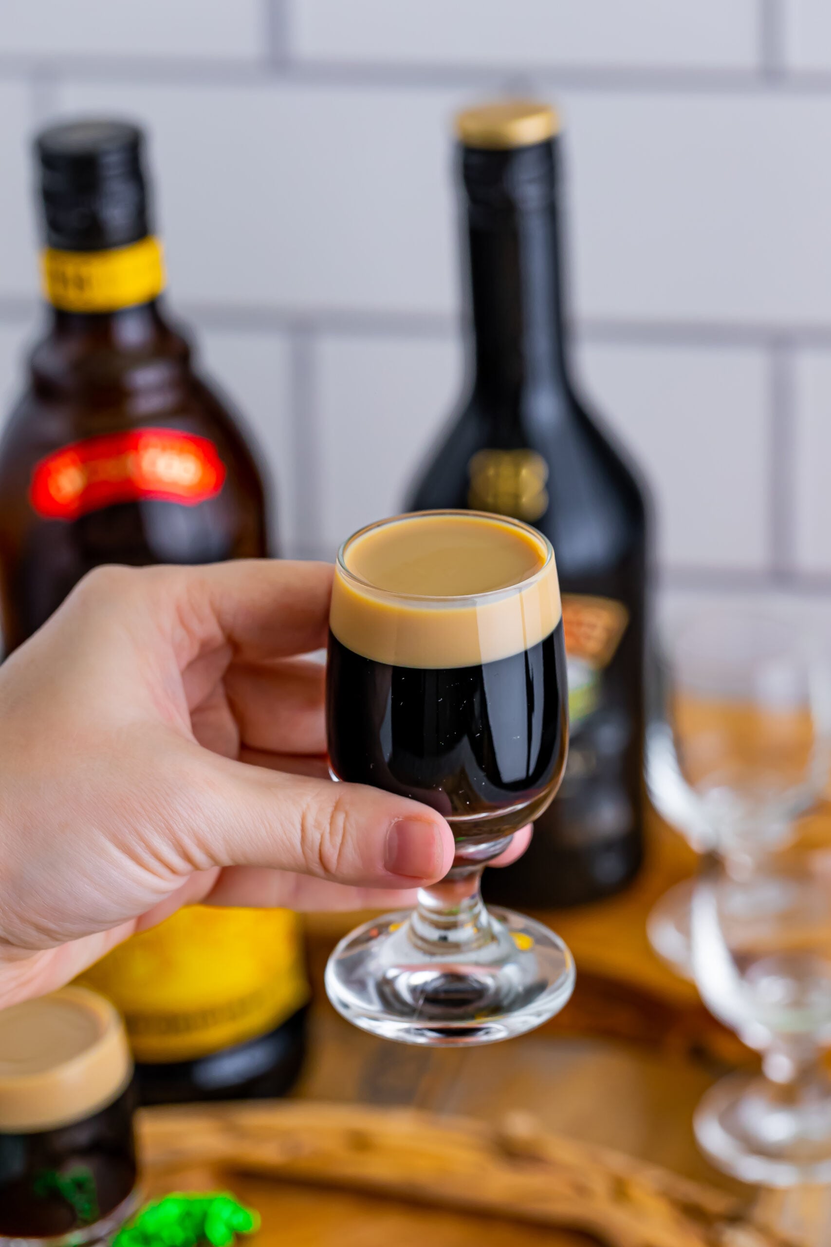 A hand holding a baby Guinness Shot. 