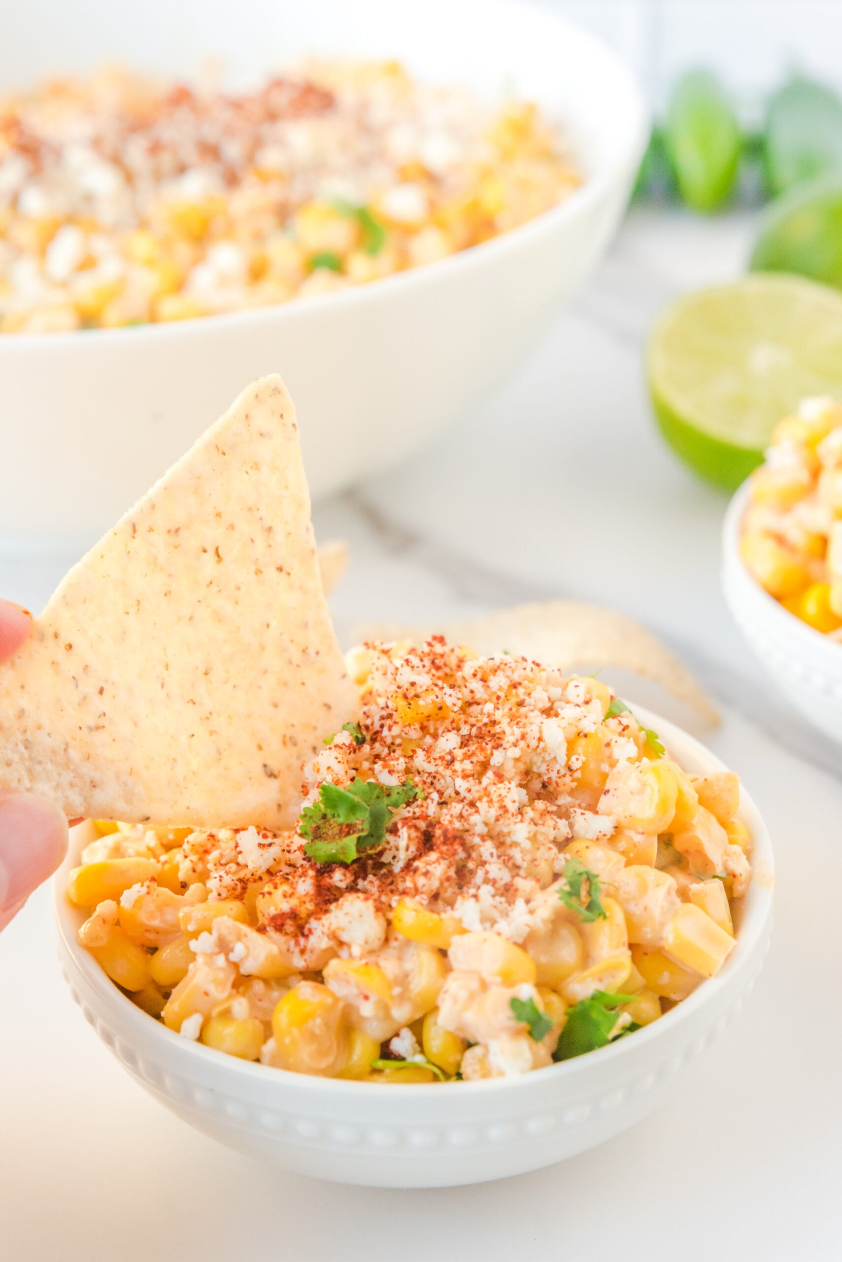 A chip being dipped into Mexican Street Corn Salad.