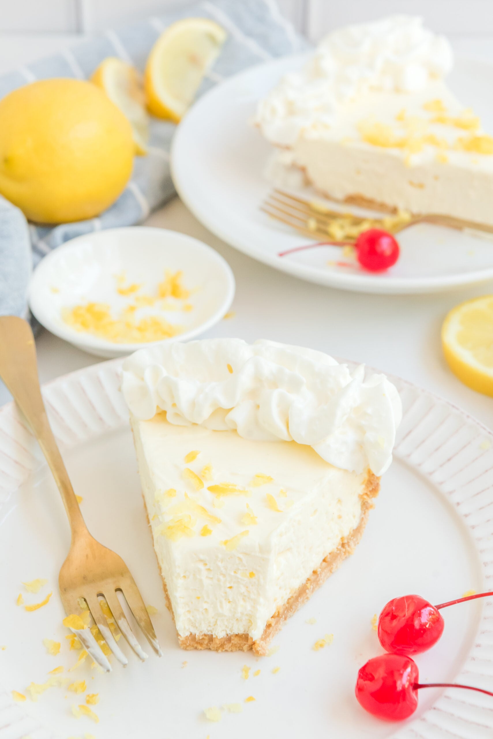 no bake lemon cheesecake pie on a white plate with a bite missing.