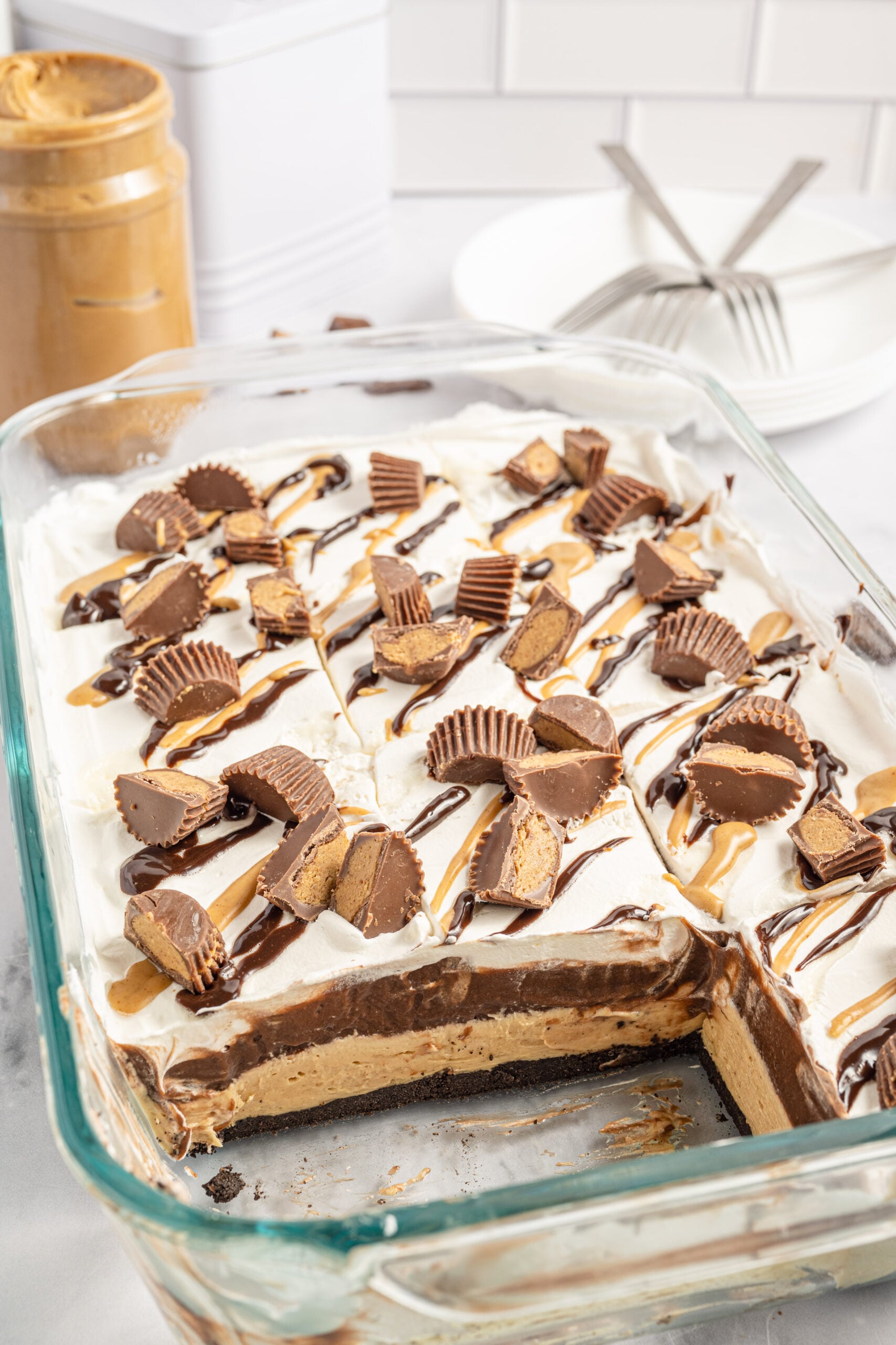 chocolate peanut butter lasagna in a glass baking pan with two slices removed.