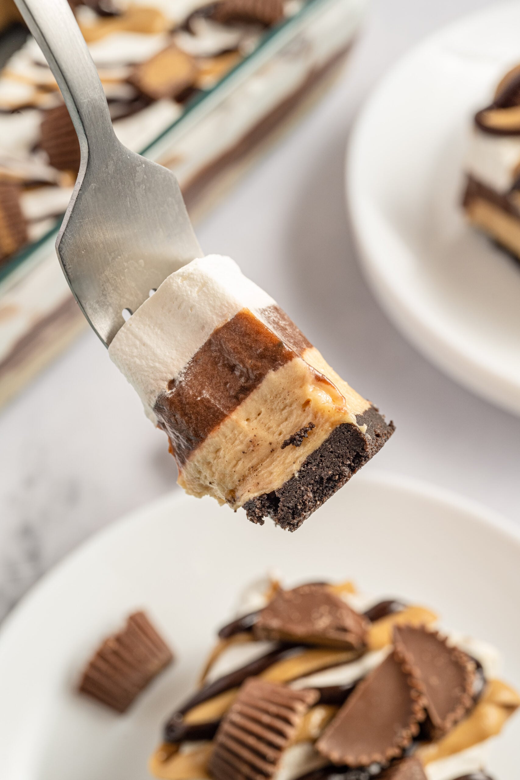 A fork removing a bite of chocolate lasagna. 