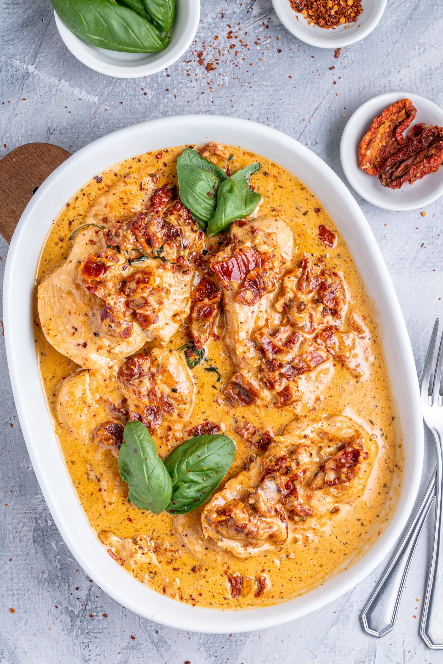 Marry Me Chicken in a white baking dish topped with fresh basil.