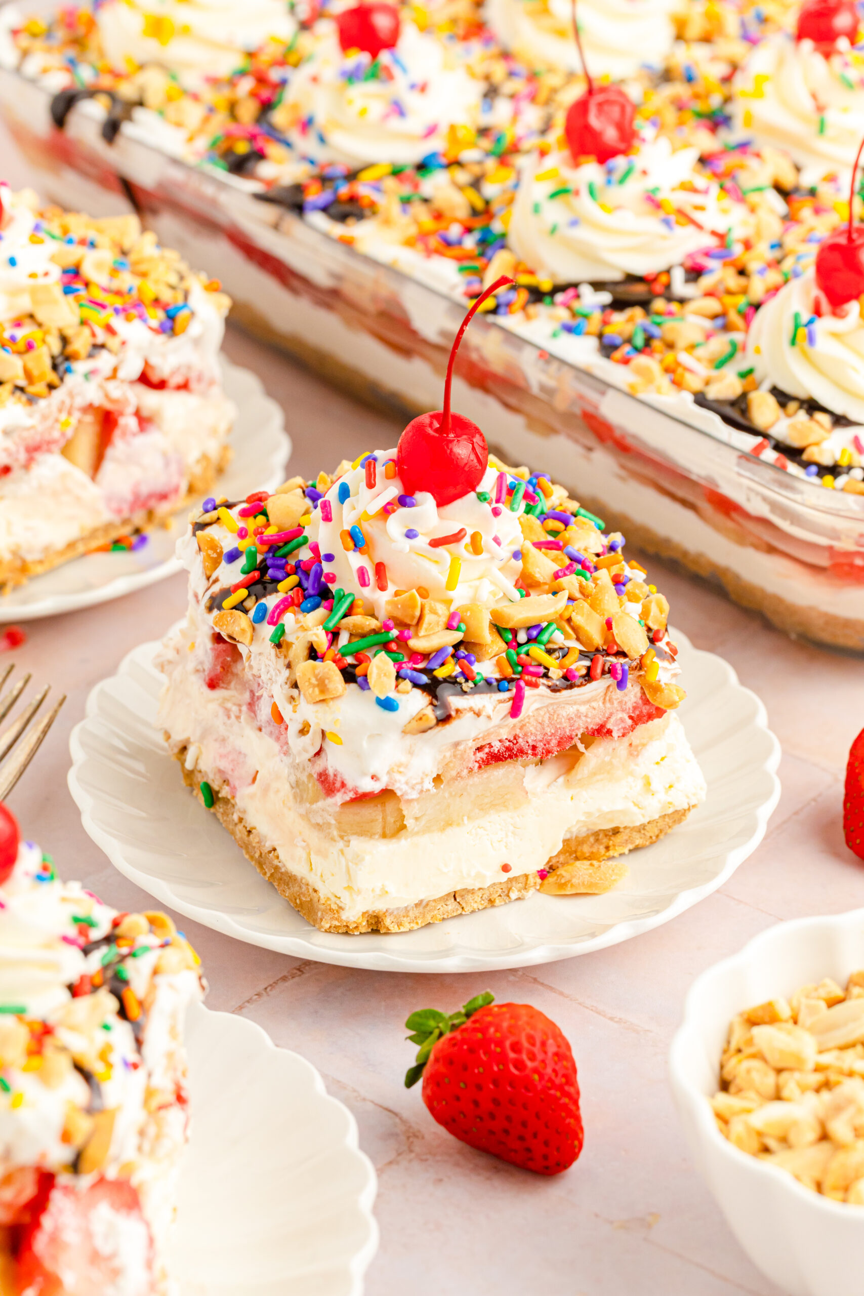 Front view of a slice of No Bake Banana Split Cake on a white plate.