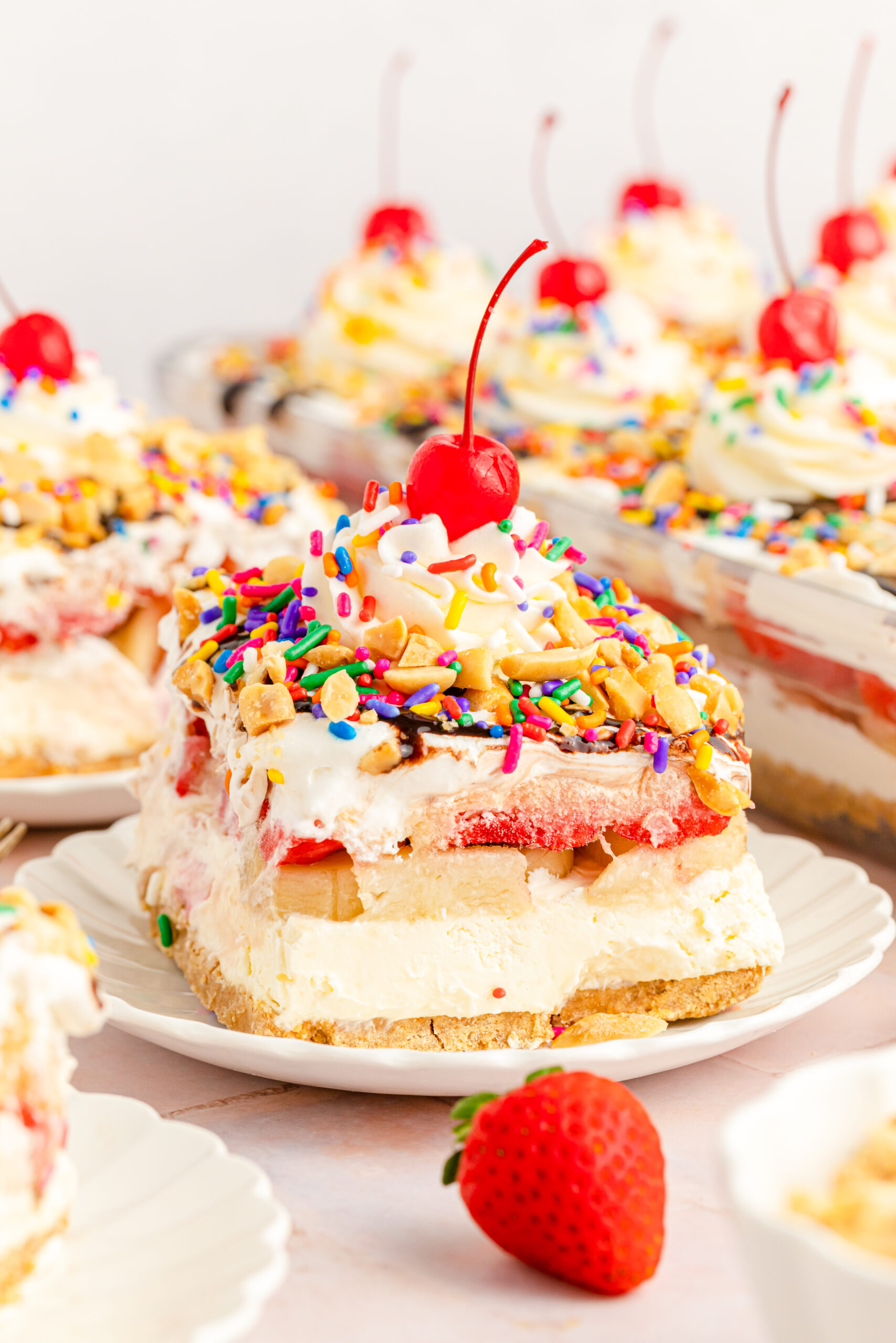 Front view of a slice of No Bake Banana Split Cake on a white plate.