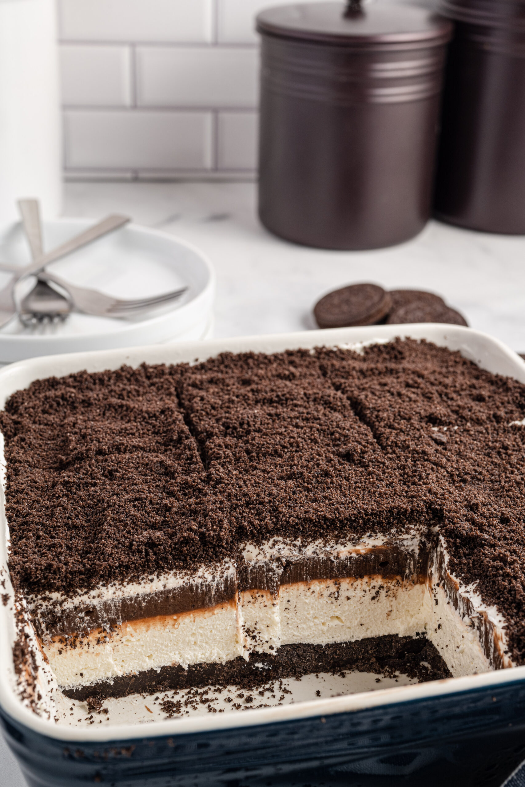 Front view of Oreo Delight in a baking dish cut into slices with two removed.