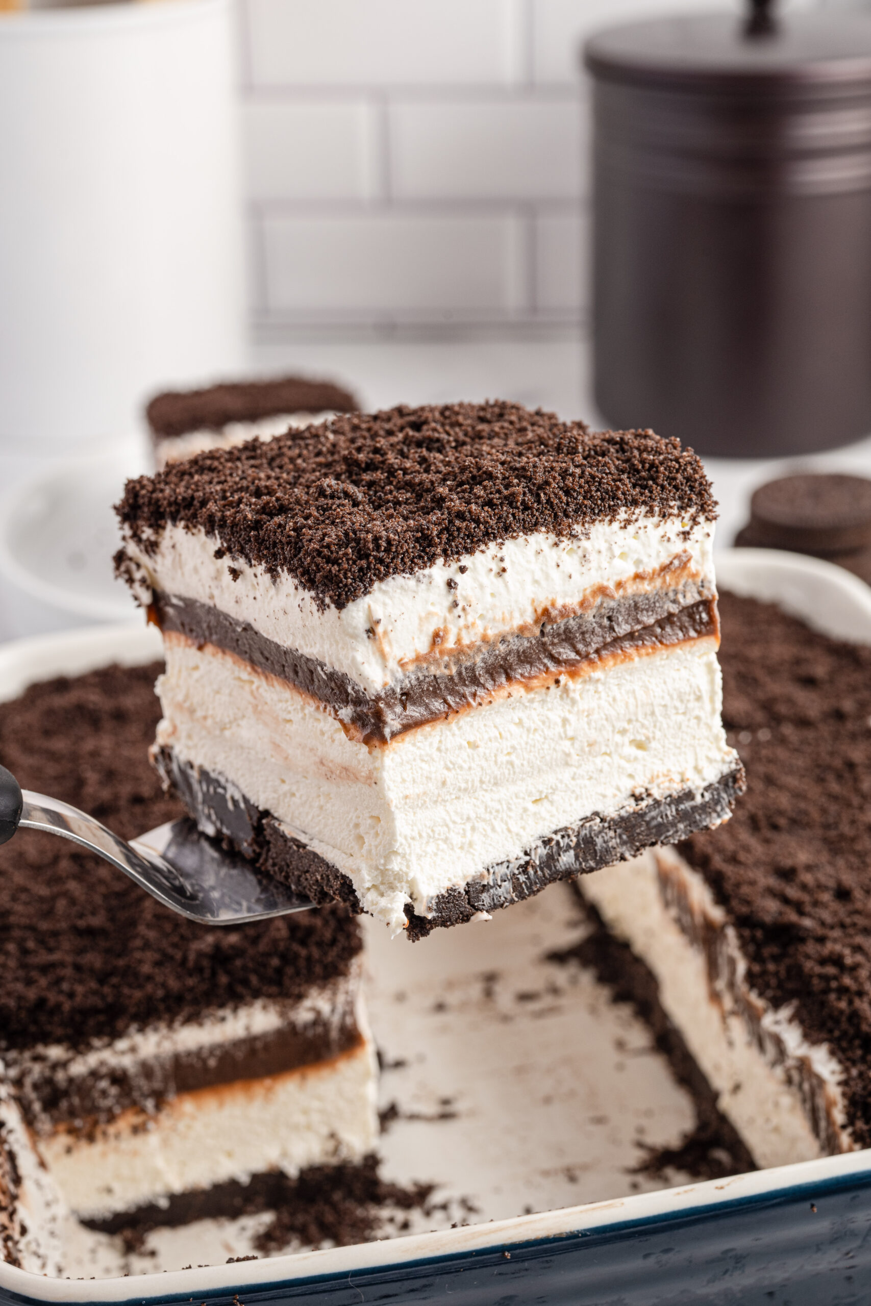 Front view of a slice of Oreo Delight on a silver cake server.