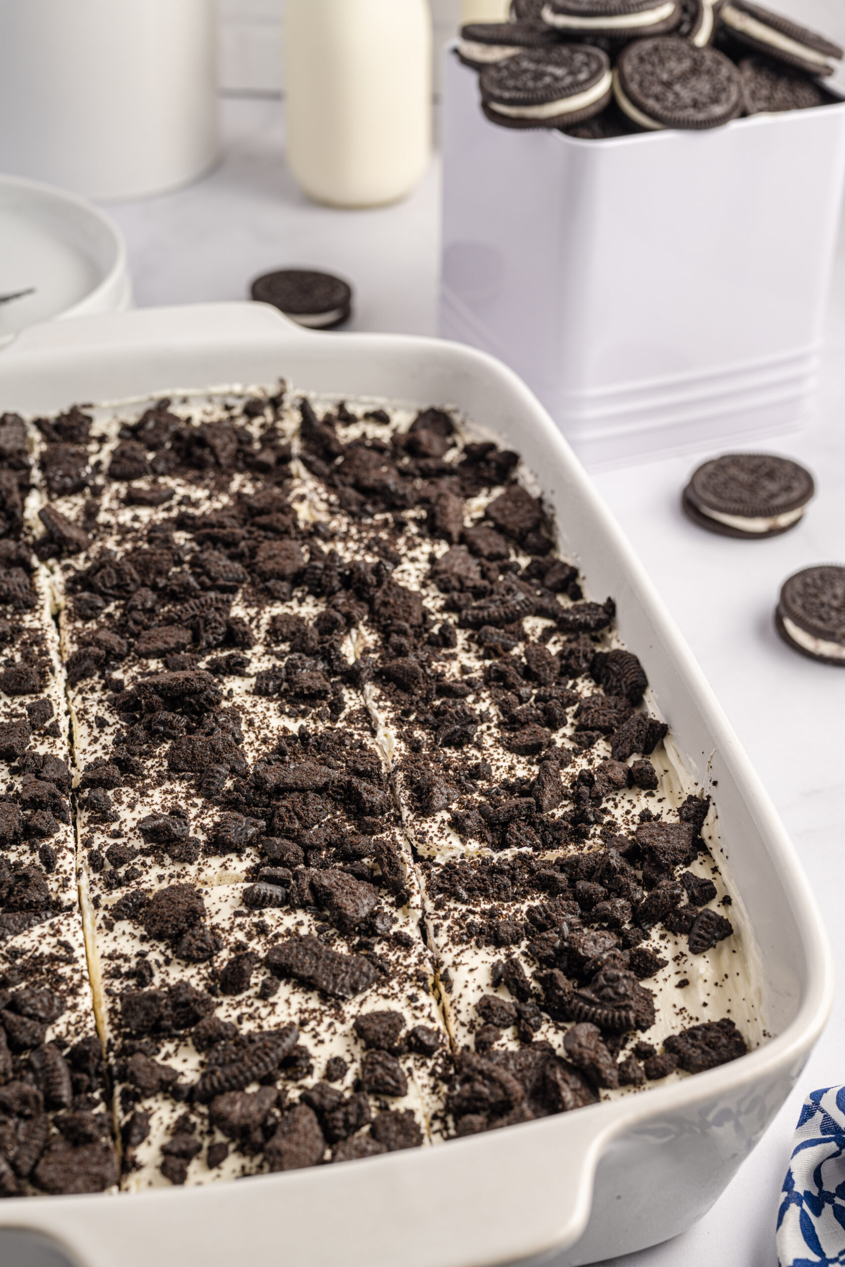 Overhead view of Oreo Icebox Cake, cut into slices, in a white baking dish.