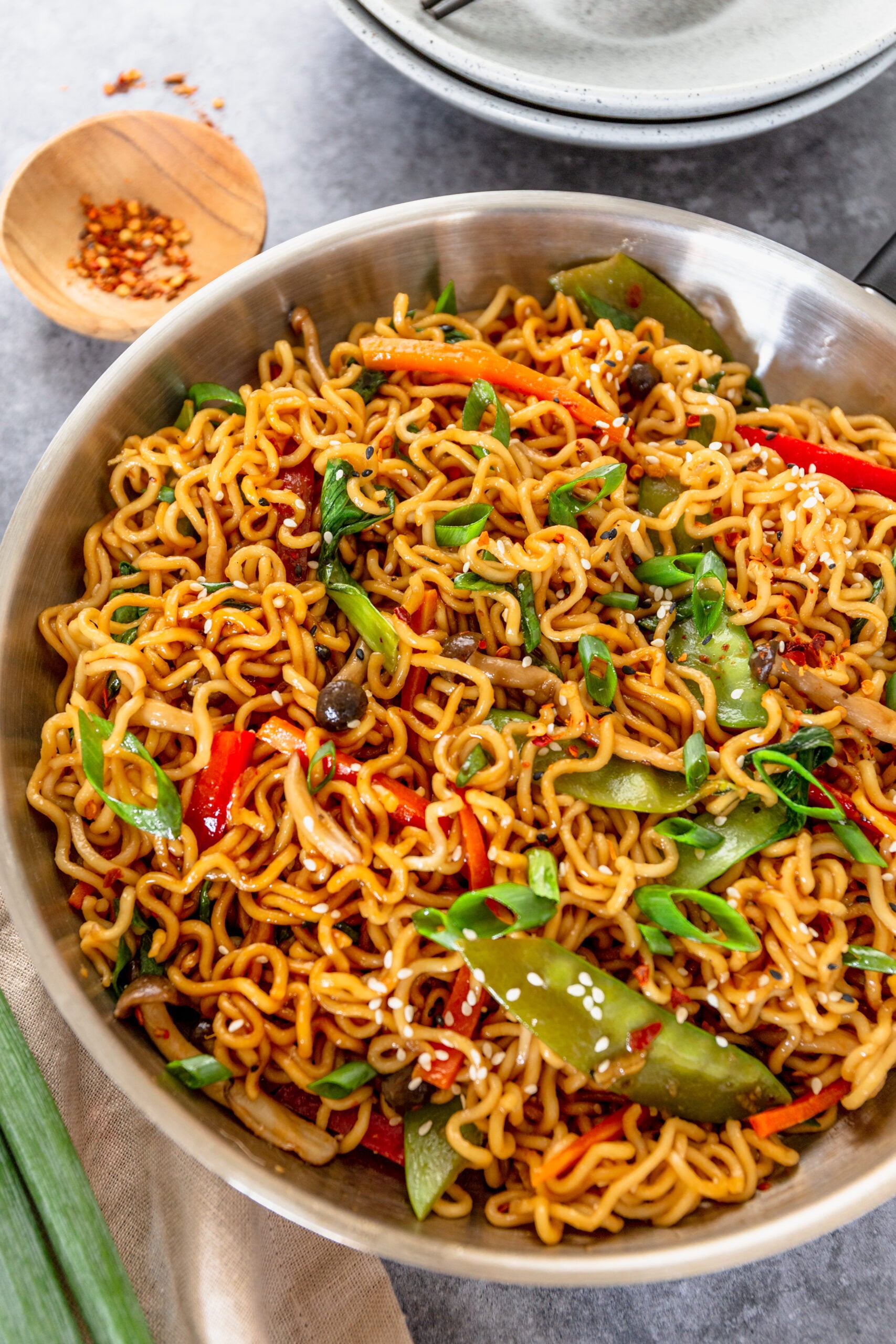 Ramen Stir Fry in a silver frying pan topped with sesame seeds.