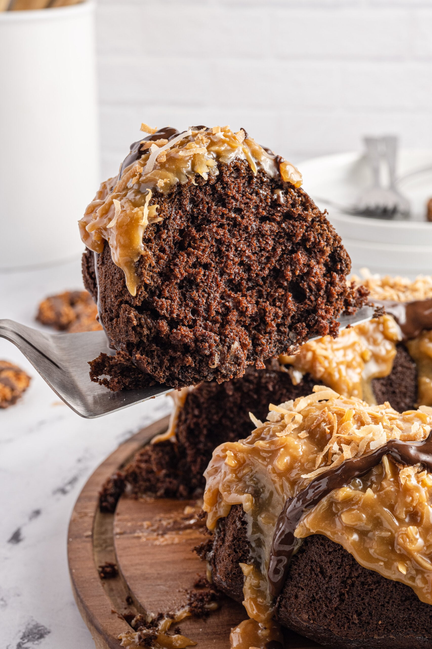 Side view of a slice of Samoa Cake on a silver cake server.