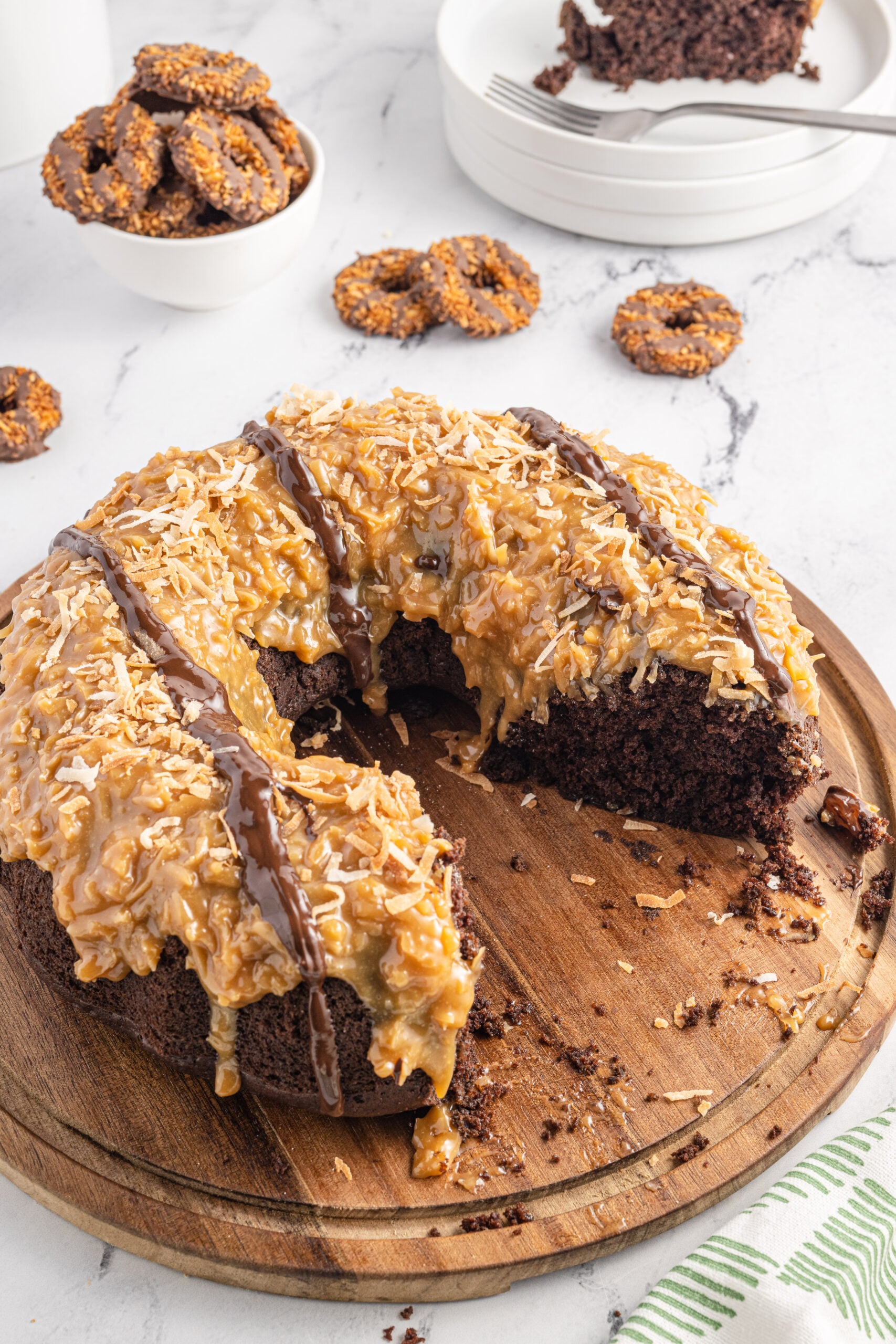 Overhead view of Samoa Cake on a wooden cutting board with slices removed.