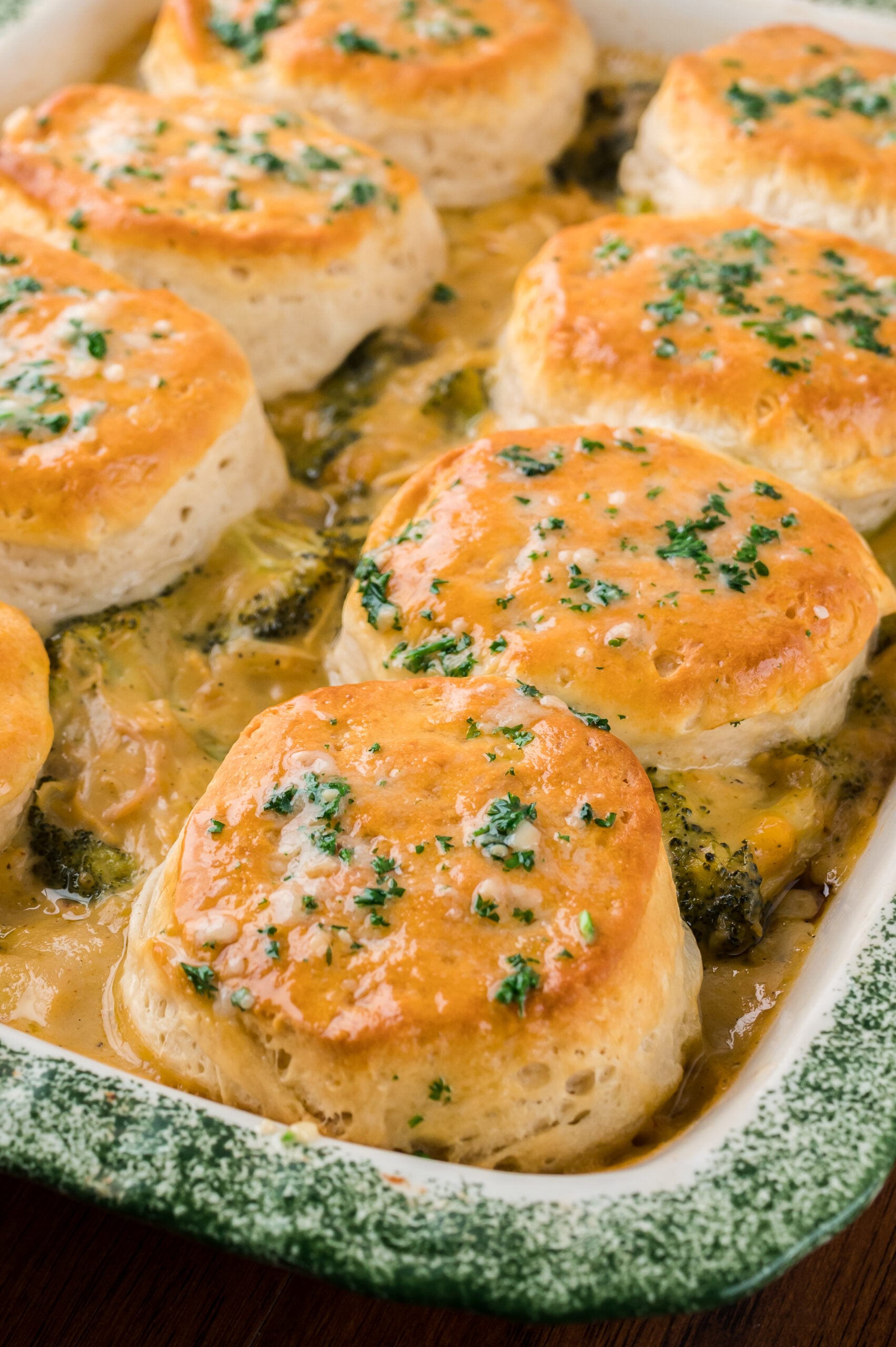 Close up view of Broccoli Cheddar Biscuit Casserole in a baking dish.