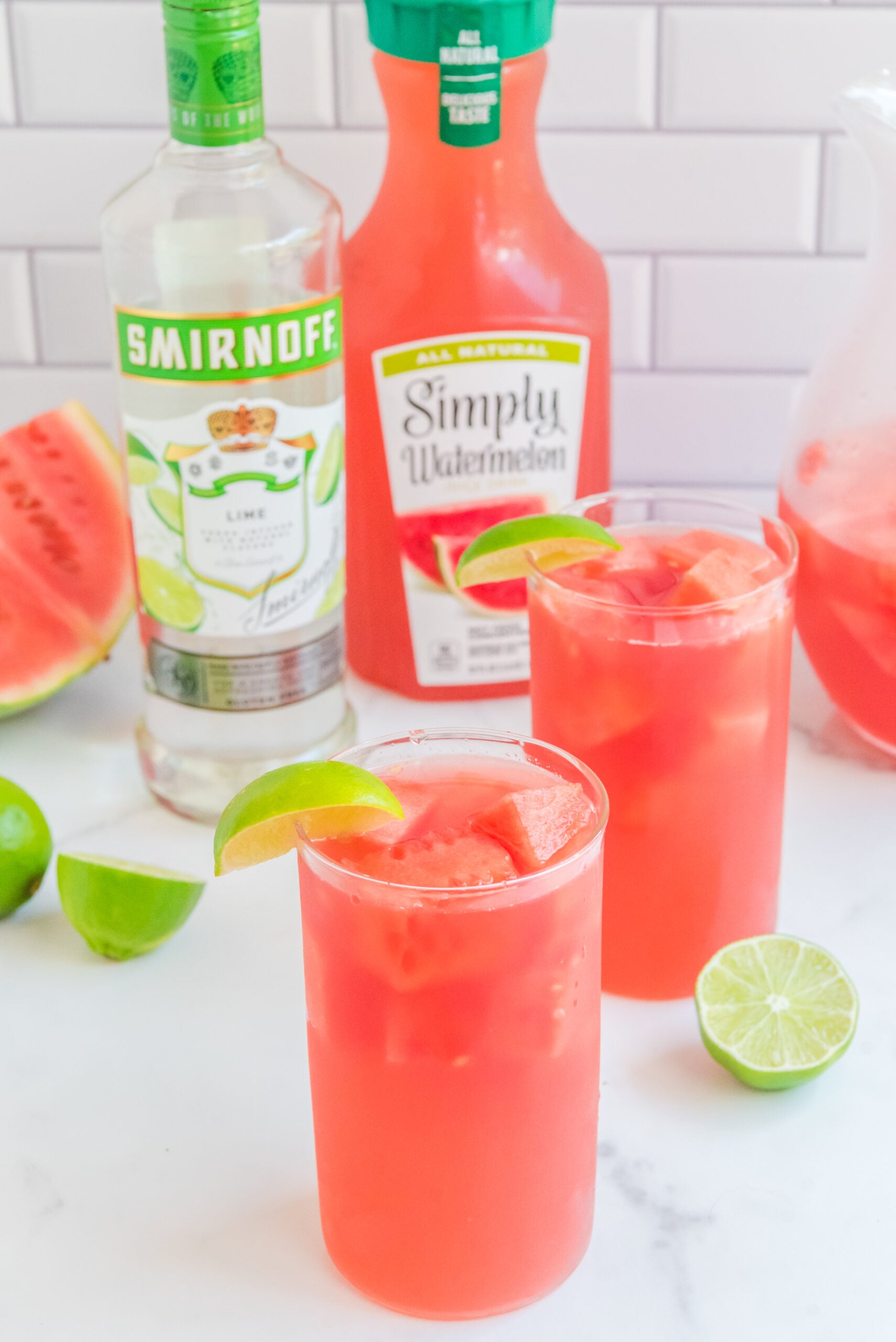 Front view of Watermelon Cocktail in two clear glasses garnished with a lime wedge.
