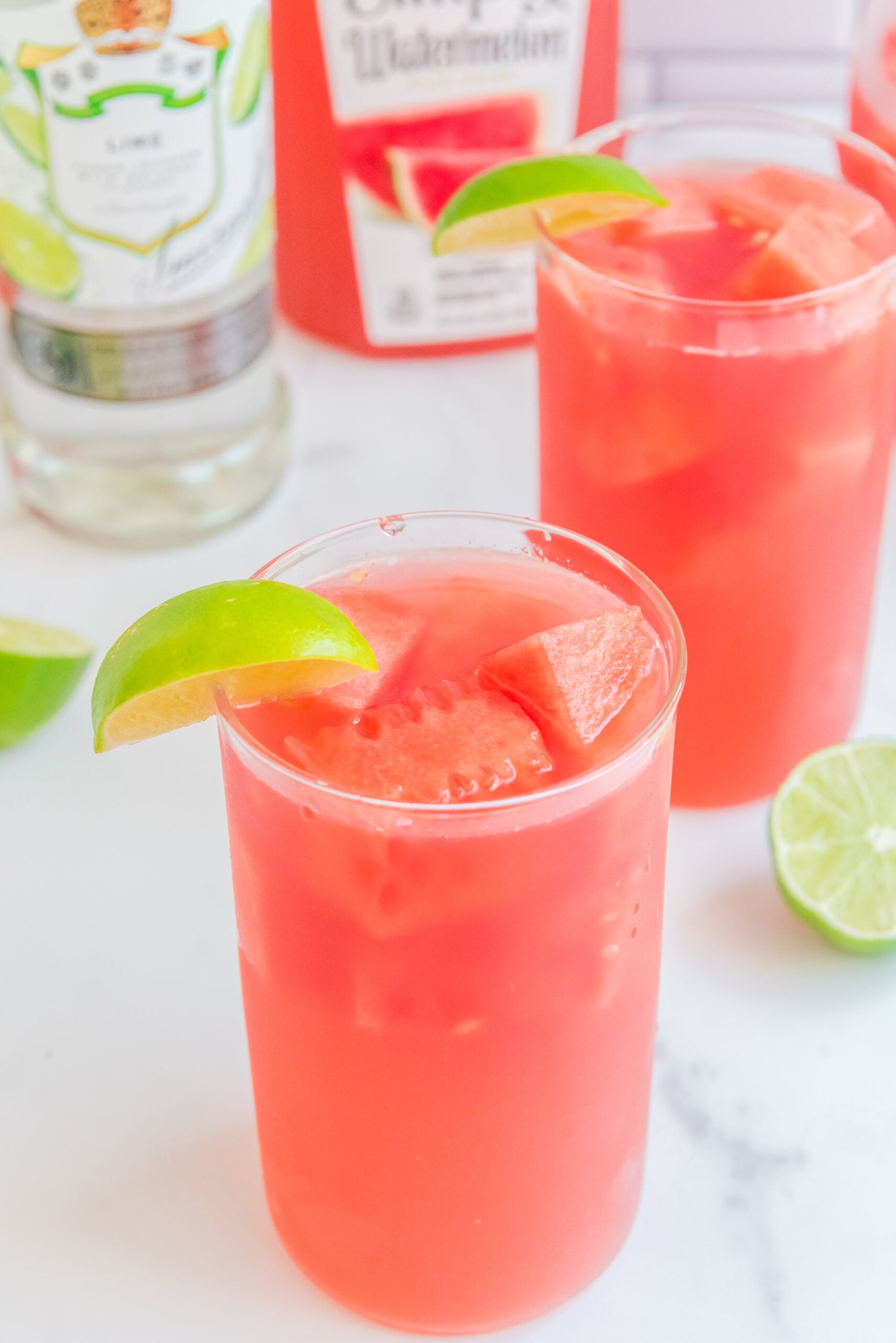 Close up view of Watermelon Cocktail in a clear glass garnished with a lime wedge.