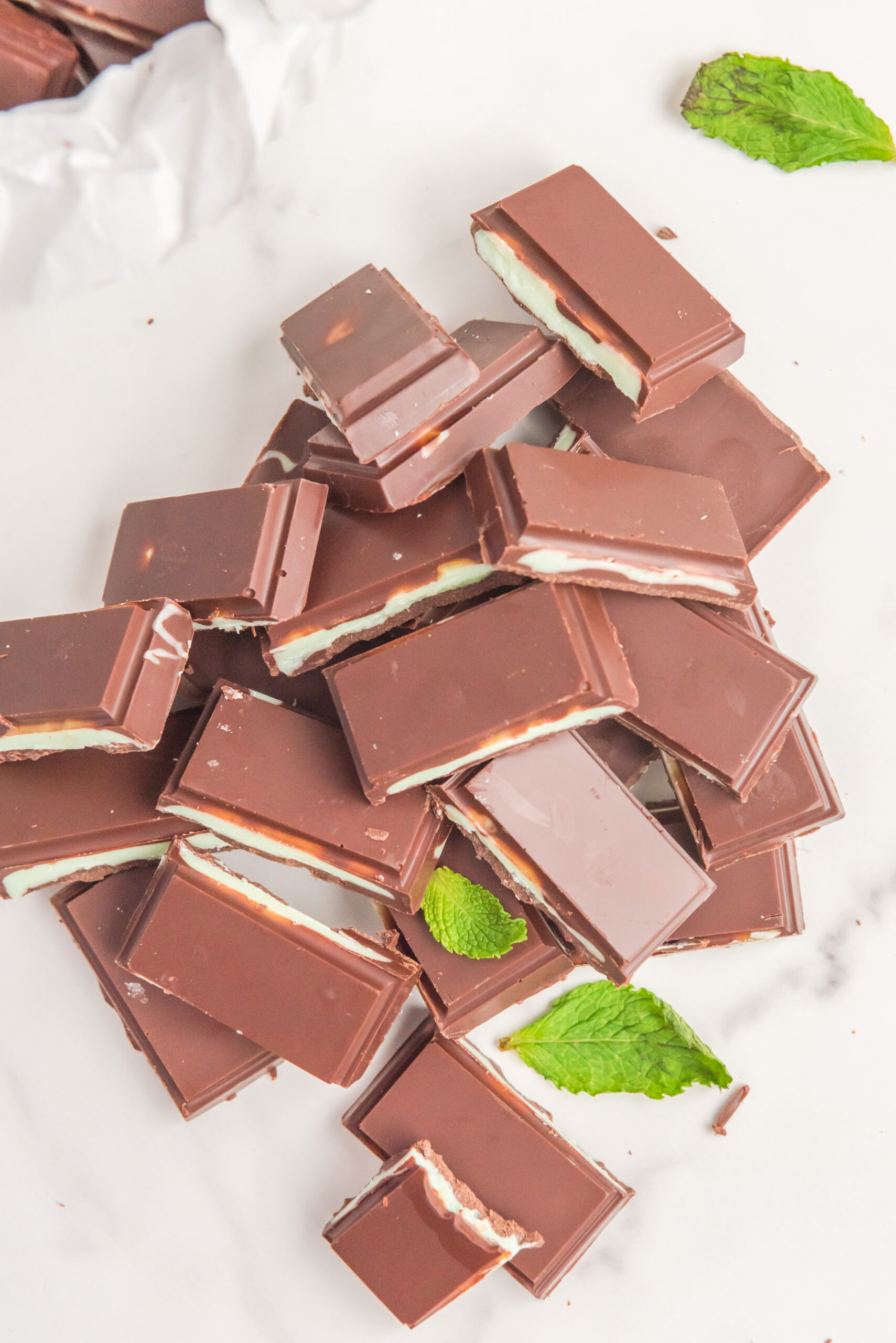 Overhead view of a pile of Homemade Andes Mints with a bite removed from one mint.