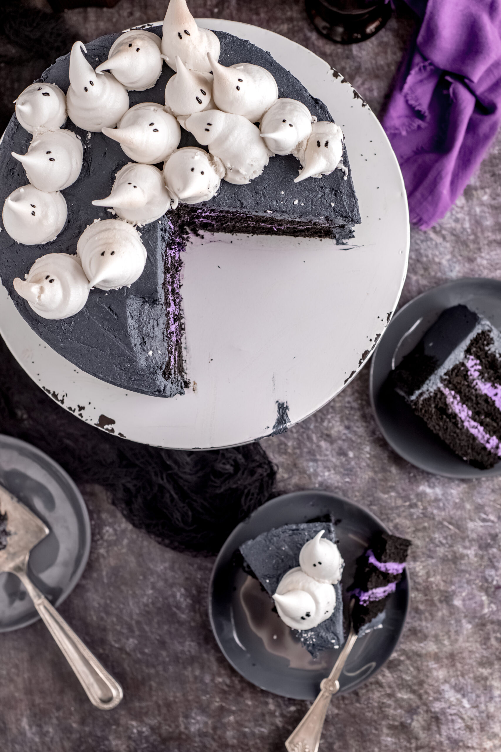 Overhead view of the Halloween cake with two pieces being served on gray plates.
