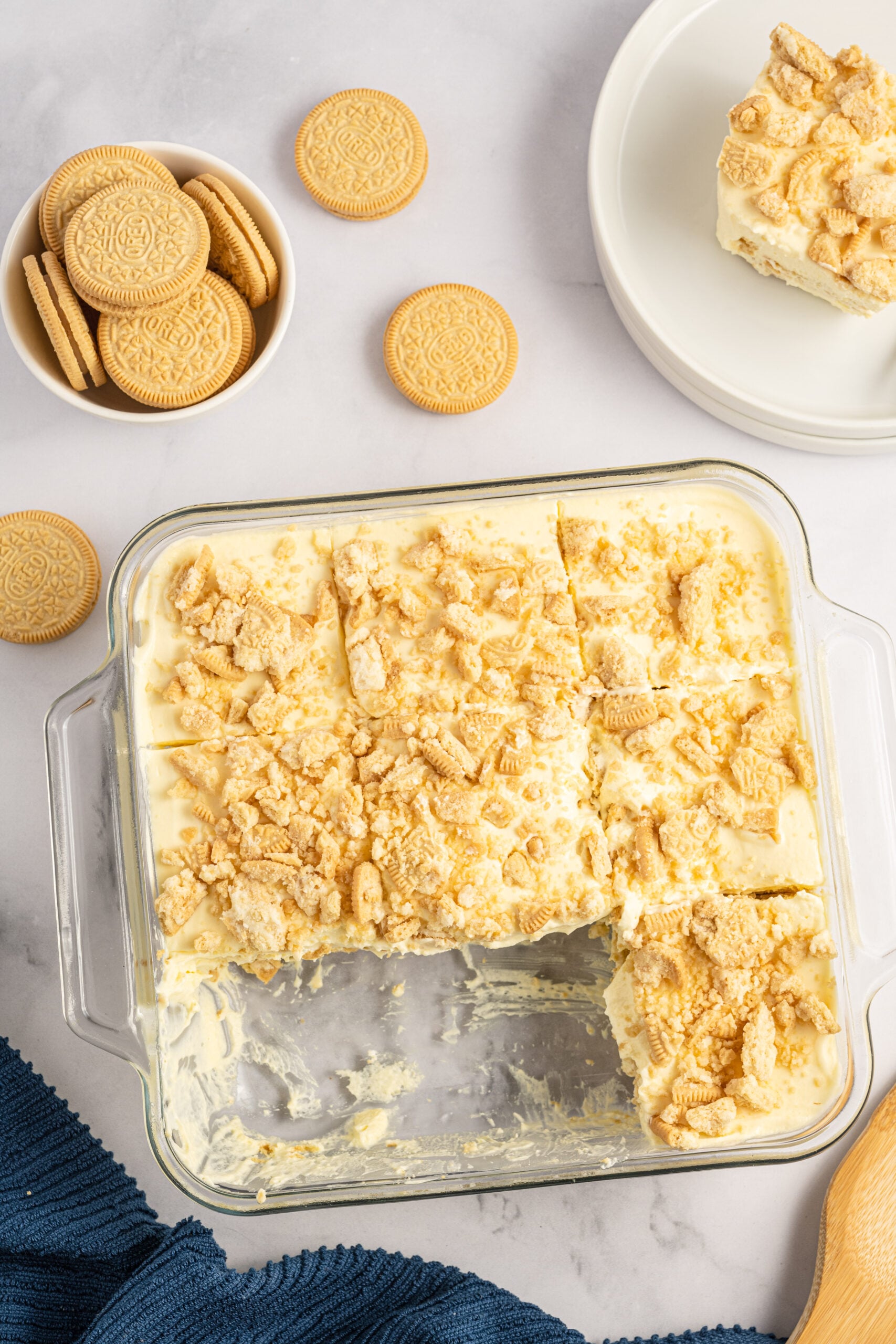Overhead view of Golden Oreo Icebox Cake in a clear baking dish with two slices removed.