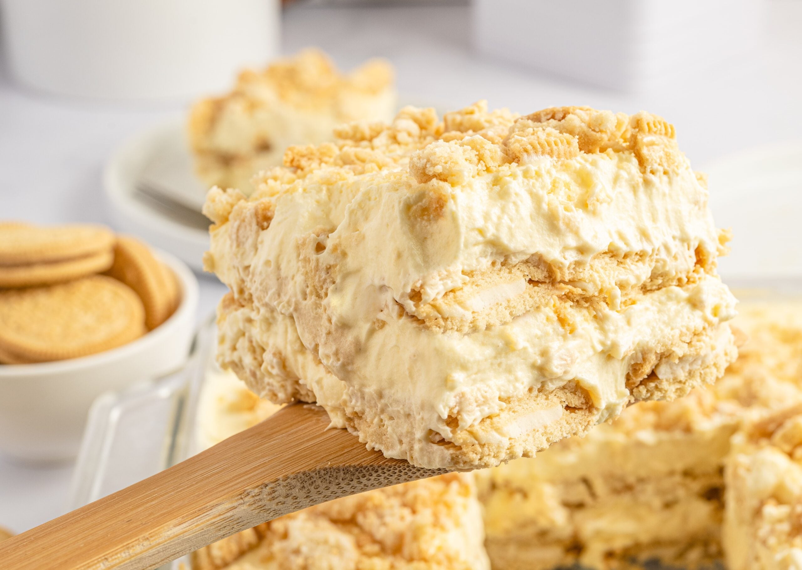 Close up view of a slice of Golden Oreo Icebox Cake being lifted up on a wooden spoon.