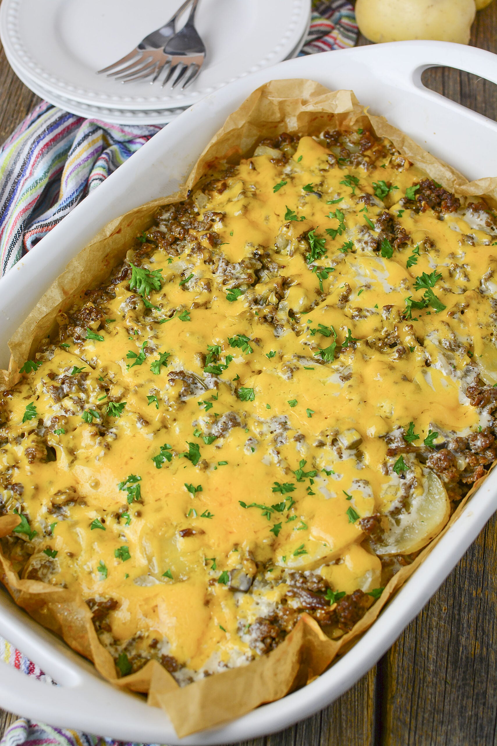 Ground Beef and Potato Casserole in a white dish topped with parsley. 