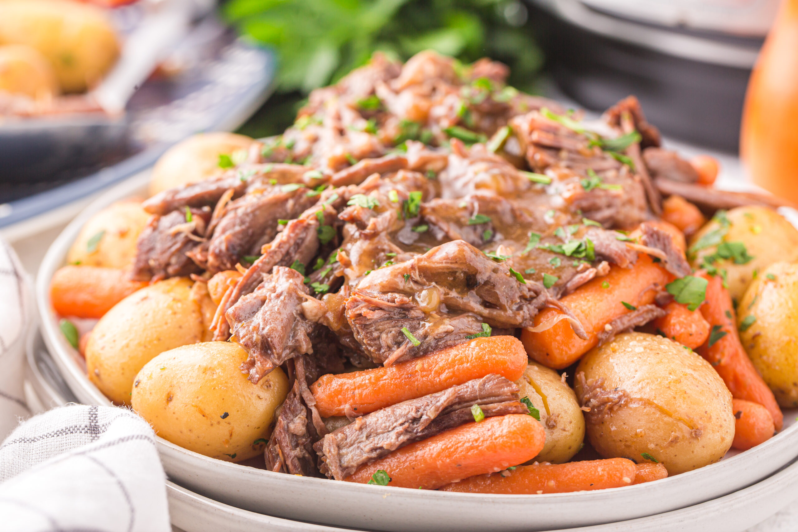 a white plate of instant pot pot roast with carrots and potatoes