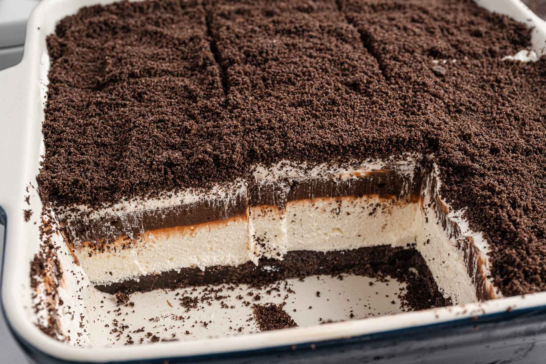 side view of Oreo Delight in a baking dish cut into slices with two removed.