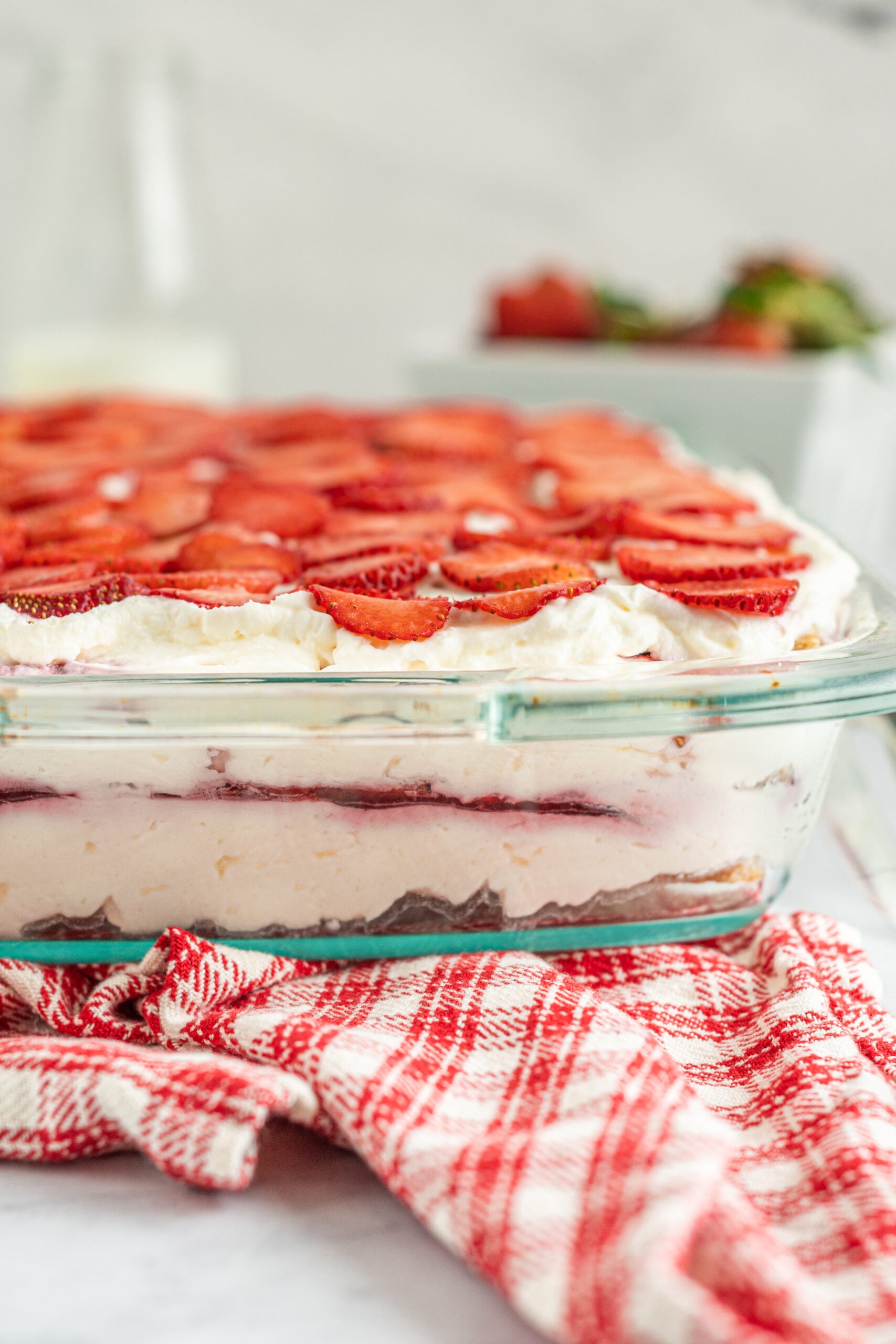 Close up side view of Strawberry Icebox Cake in a clear baking dish. 