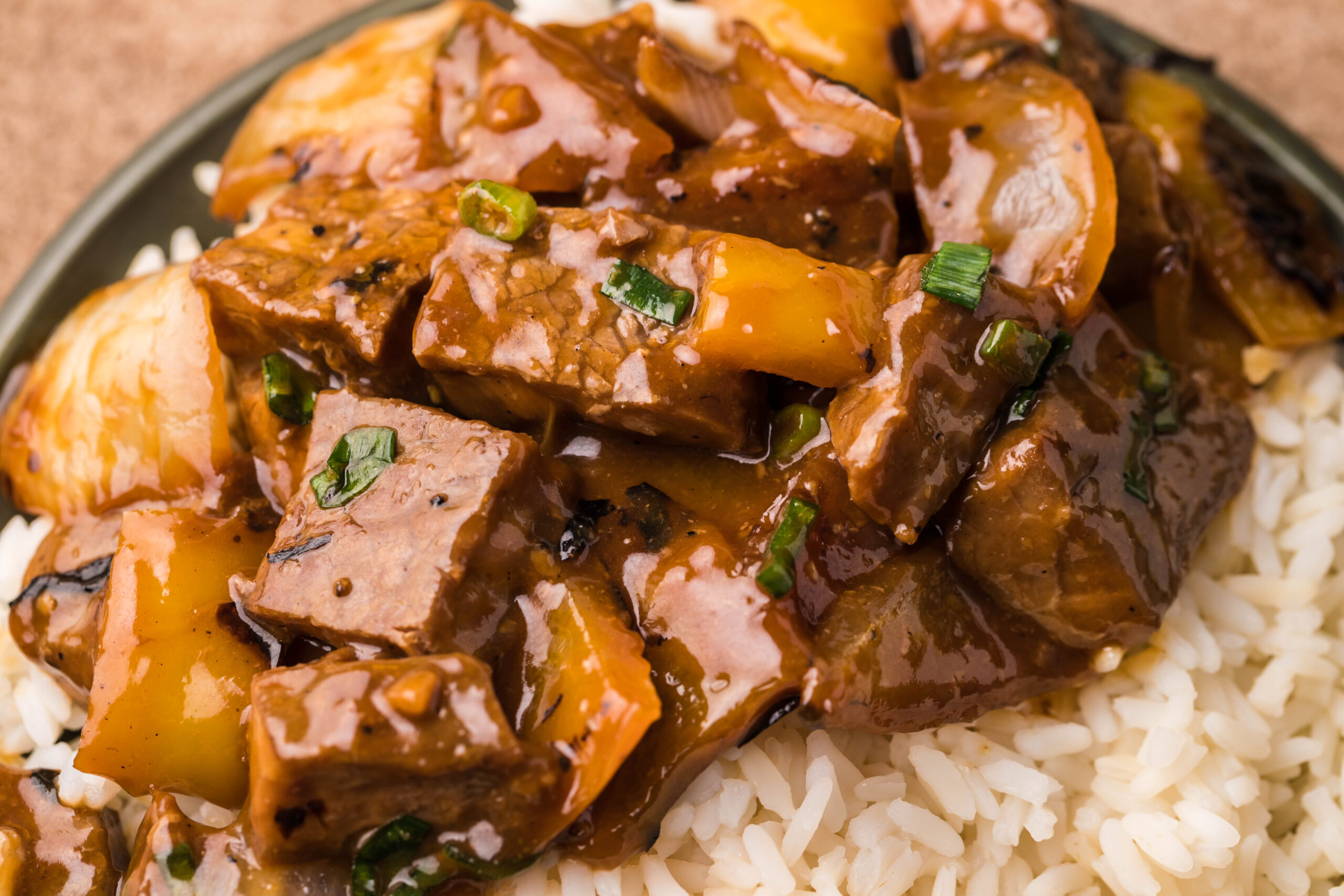 Close up view of Teriyaki Steak Bites in a black dish with a side of white rice.