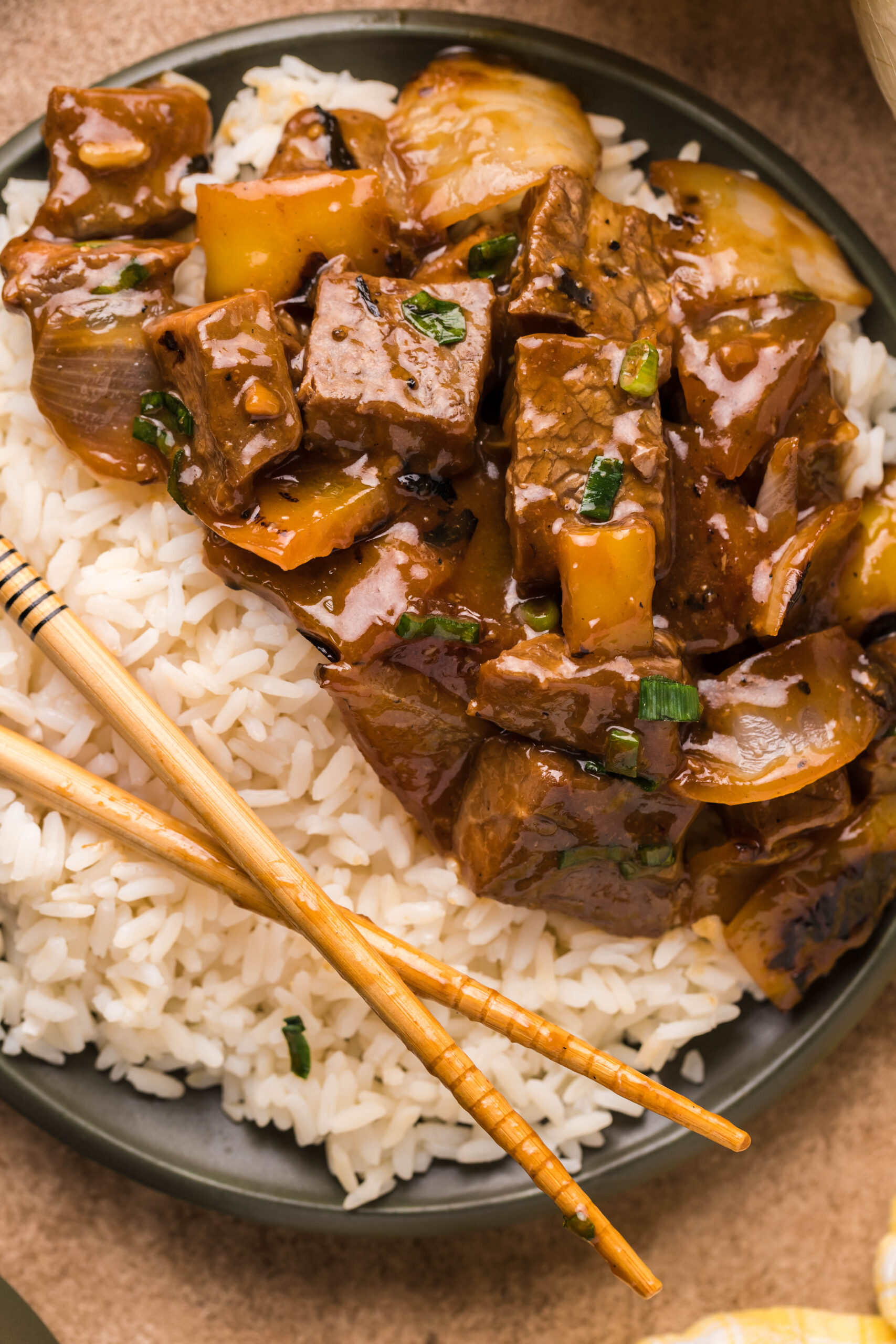 Overhead view of Teriyaki Steak Bites in a black dish served with white rice.