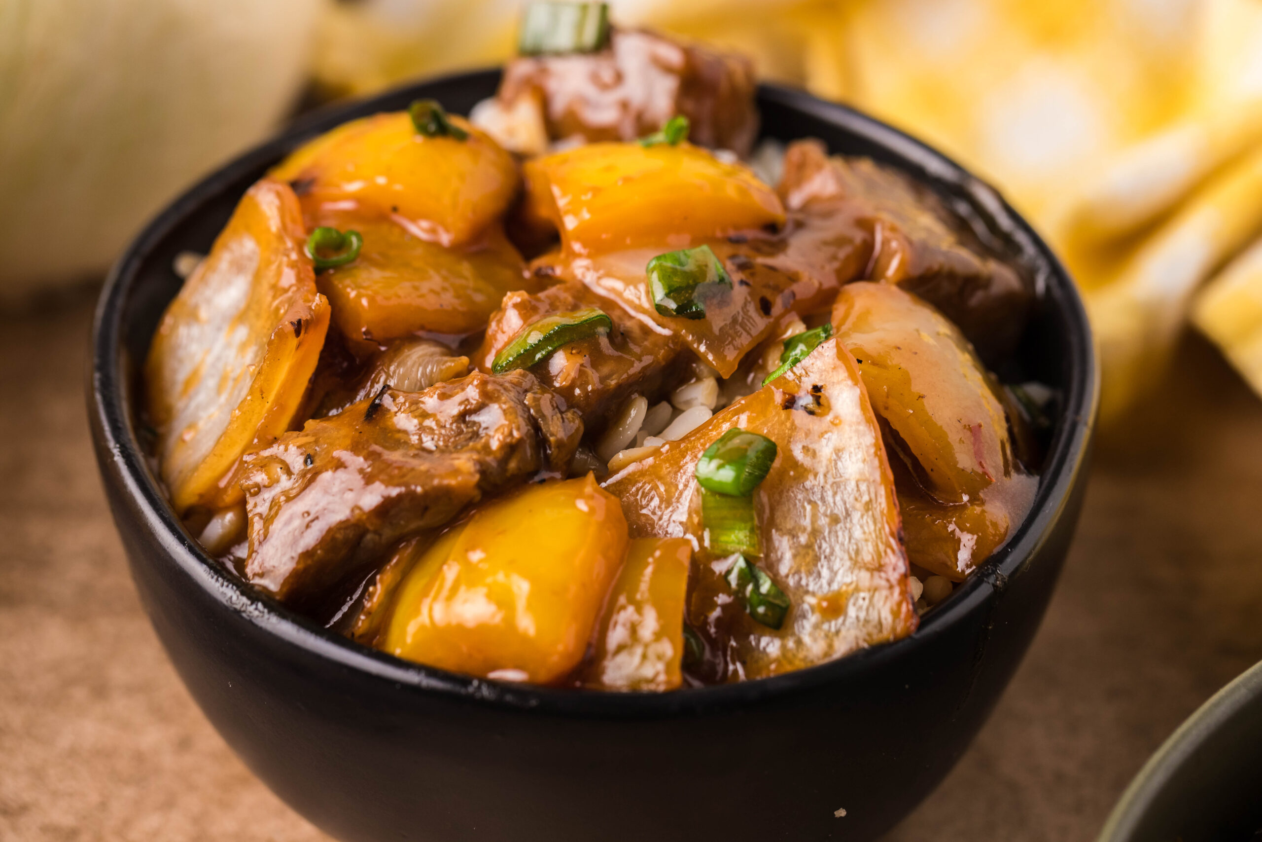 Front view of Teriyaki Steak Bites in a black dish served with white rice.