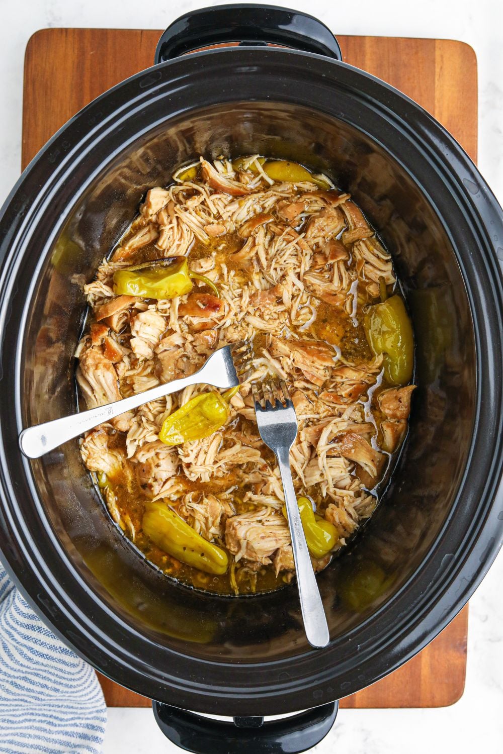 chicken being shredded with two forks