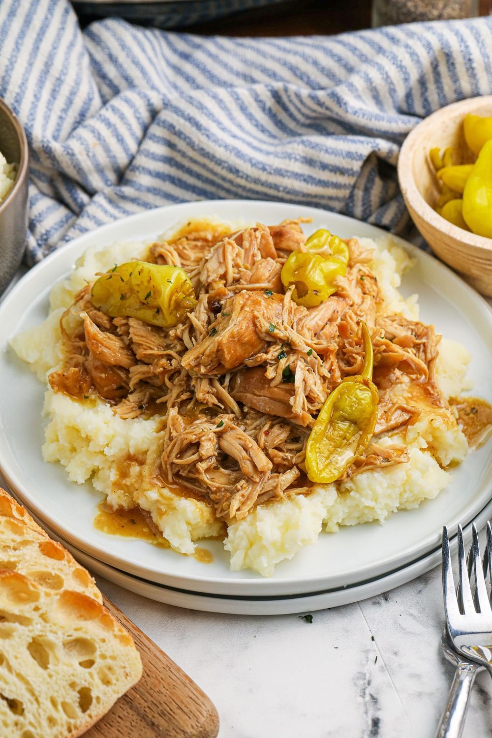 mississippi chicken on plate with bread on the side of table