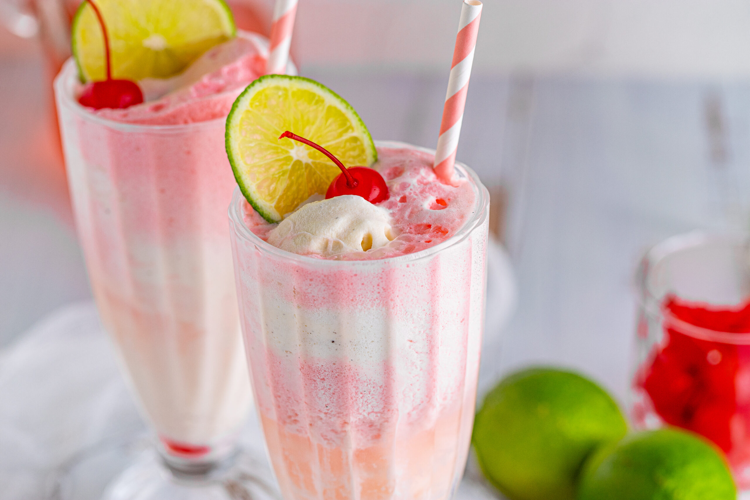 Front view of Dirty Shirley Float in a clear glass topped with a lime slice and cherry.