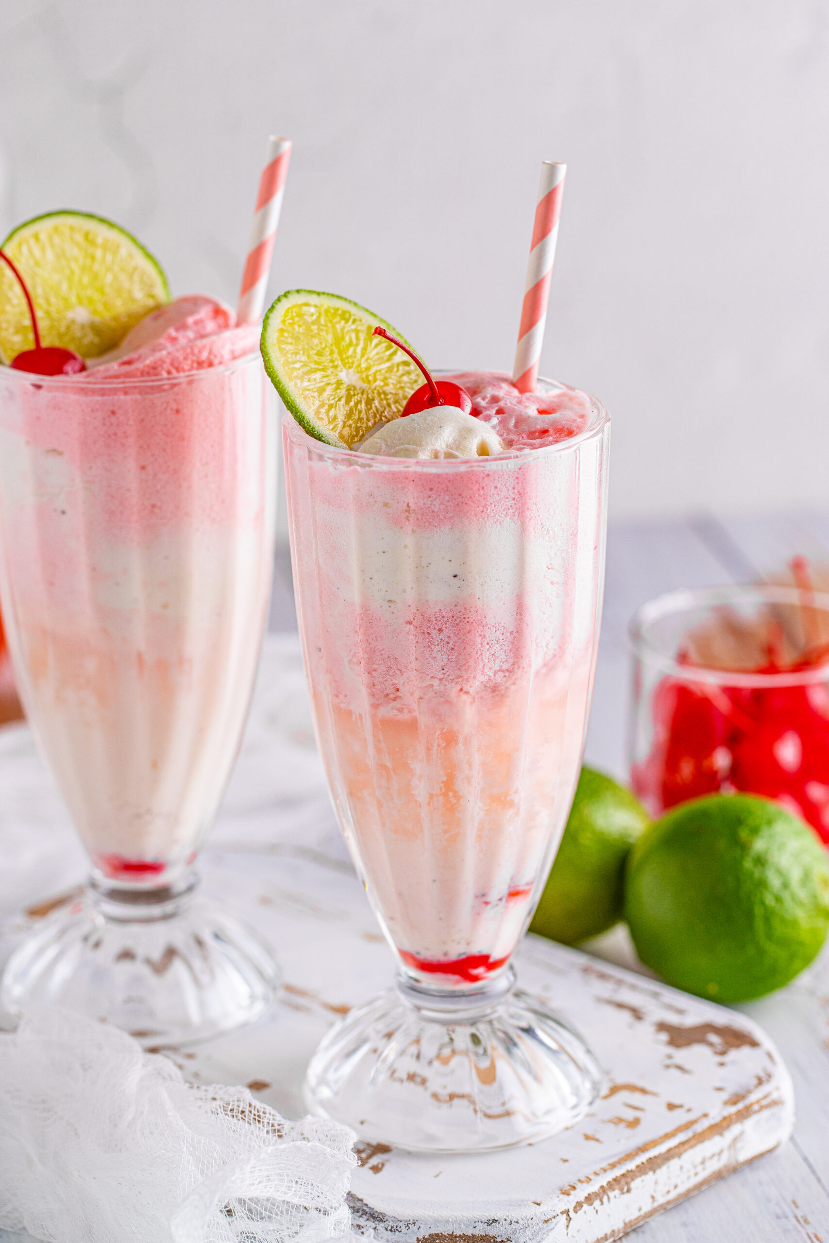 Front view of Dirty Shirley Float in a clear glass topped with a lime slice and cherry.