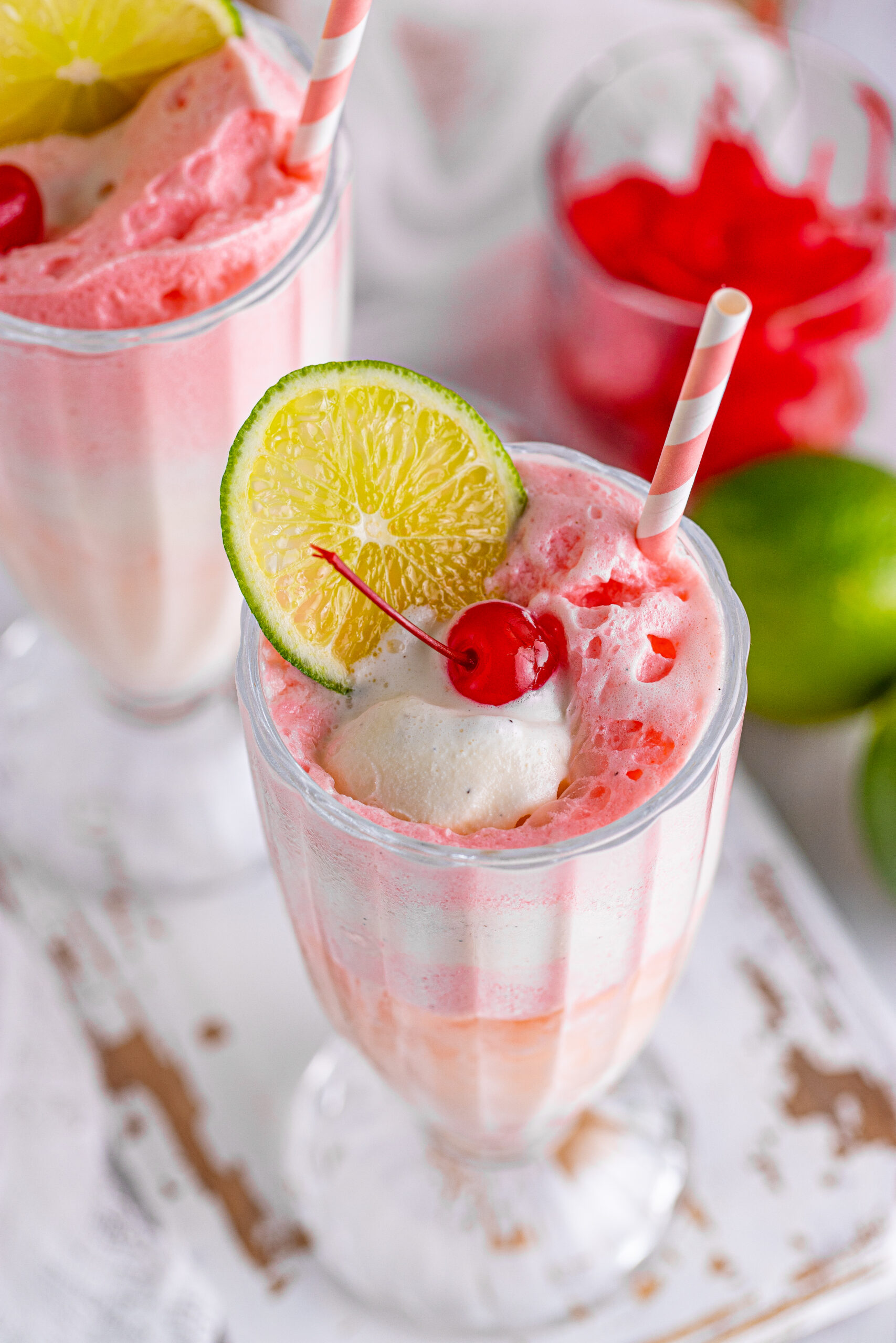 Overhead view of Dirty Shirley Float in a clear glass topped with a lime slice and cherry.