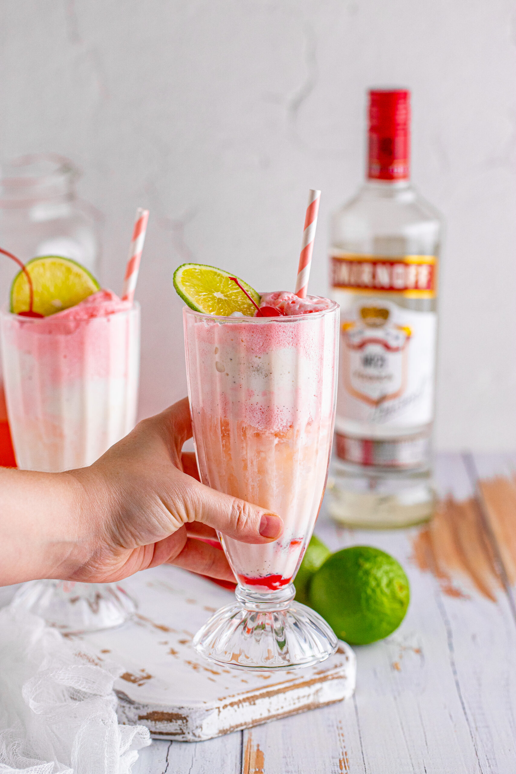 Front view of Dirty Shirley Float in a clear glass topped with a lime slice and cherry.