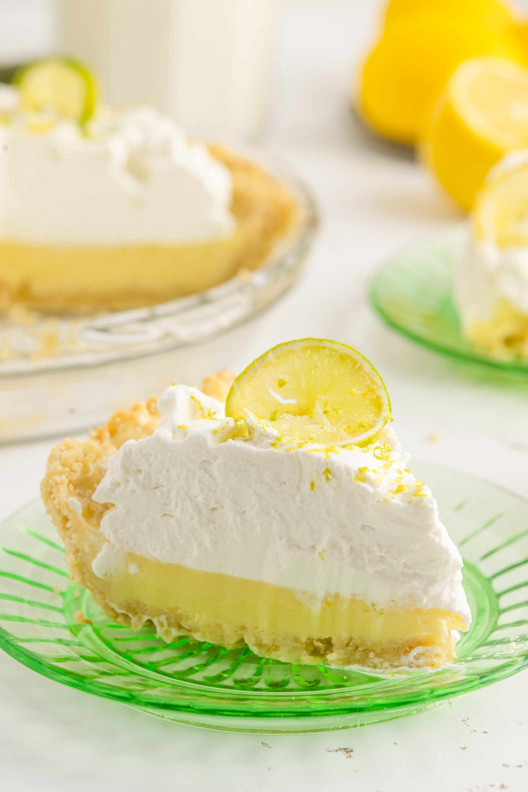 A piece of Atlantic Beach Pie on a green plate topped with a fresh lemon.
