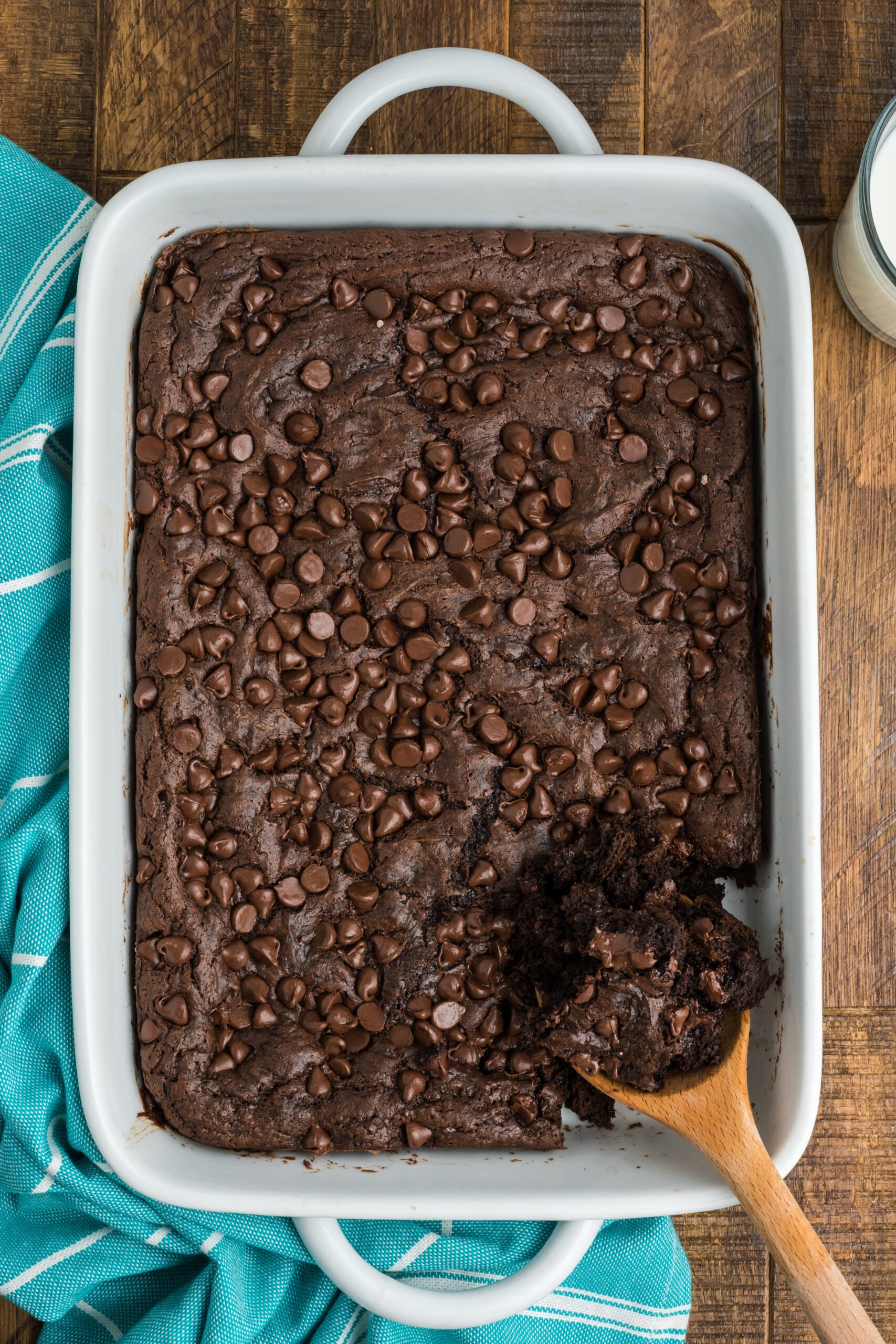 Overhead view of a wooden spoon removing a serving of Chocolate Dump Cake.