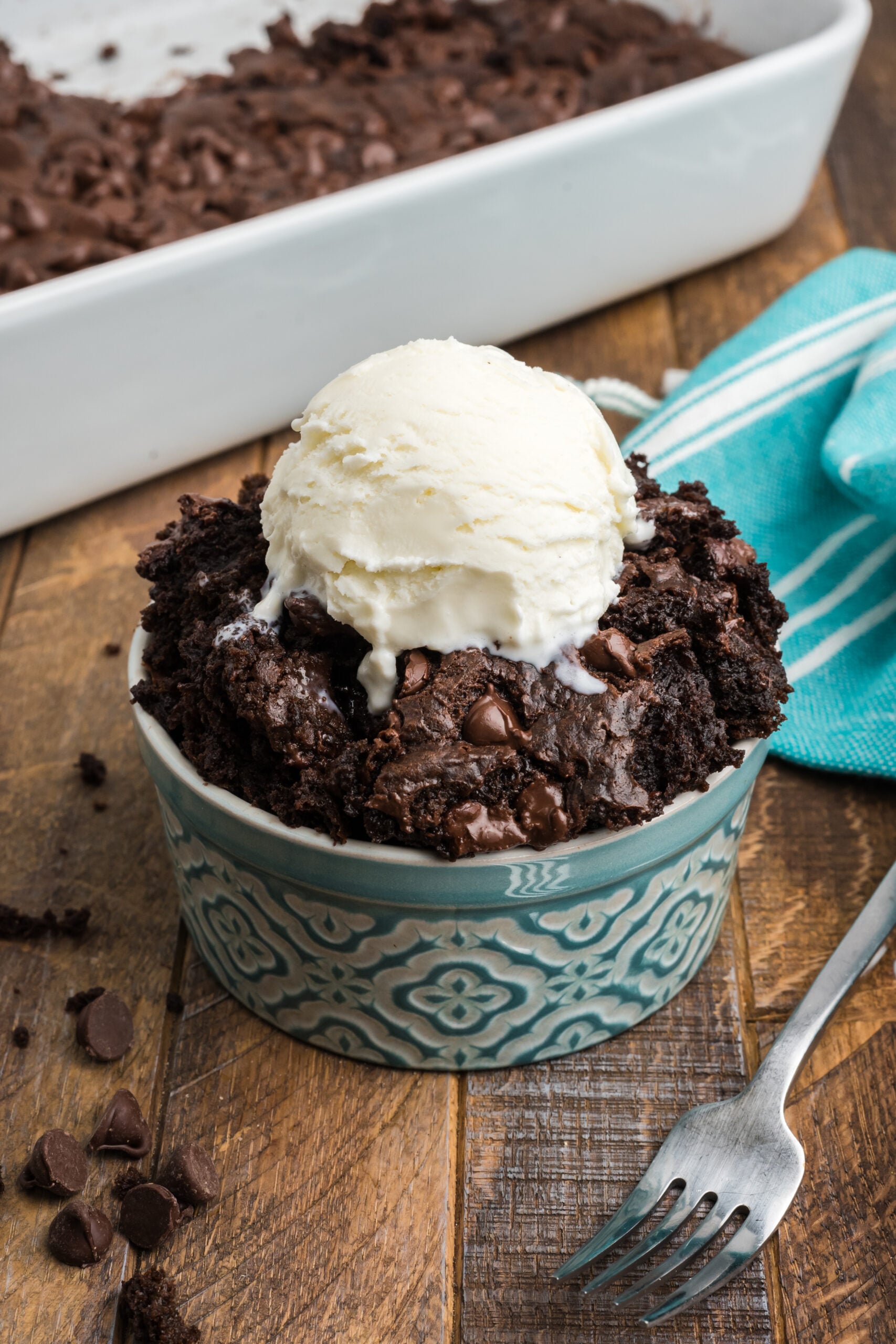 Front view of a serving of Chocolate Dump Cake in a bowl topped with a scoop of ice cream.