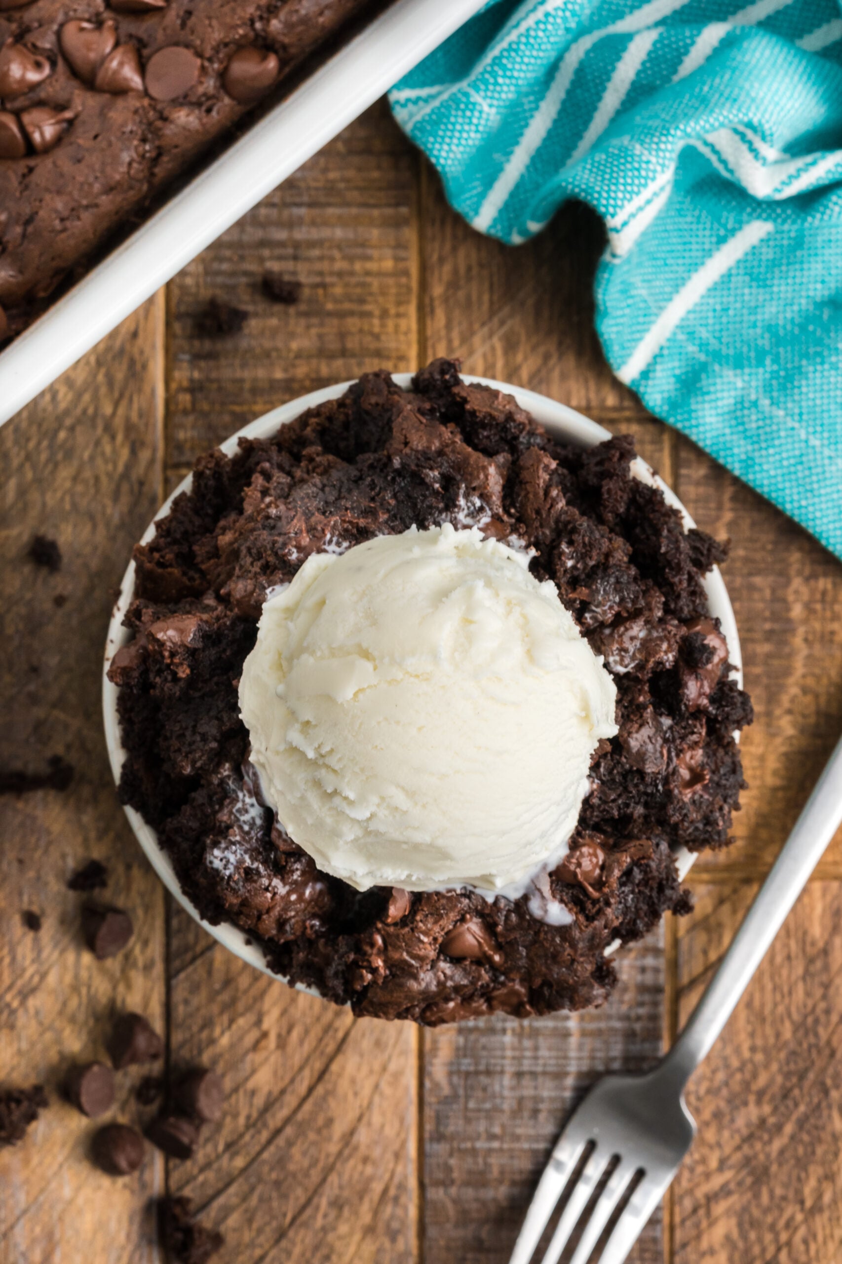 Overhead view of a serving of Chocolate Dump Cake in a bowl topped with a scoop of ice cream.