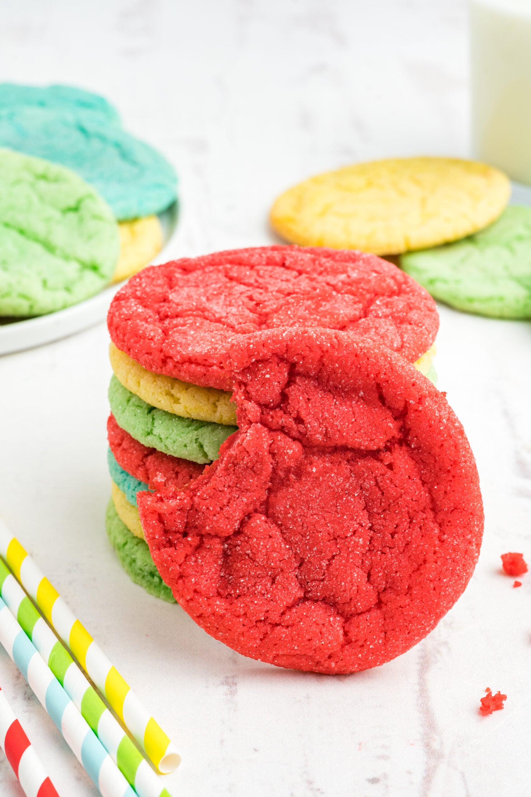 Front view of a Jello Cookie, with a bite removed, propped on a stack of cookies
